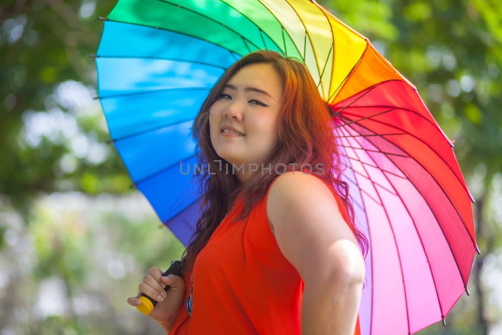 Happy fatty woman with umbrella by witthaya