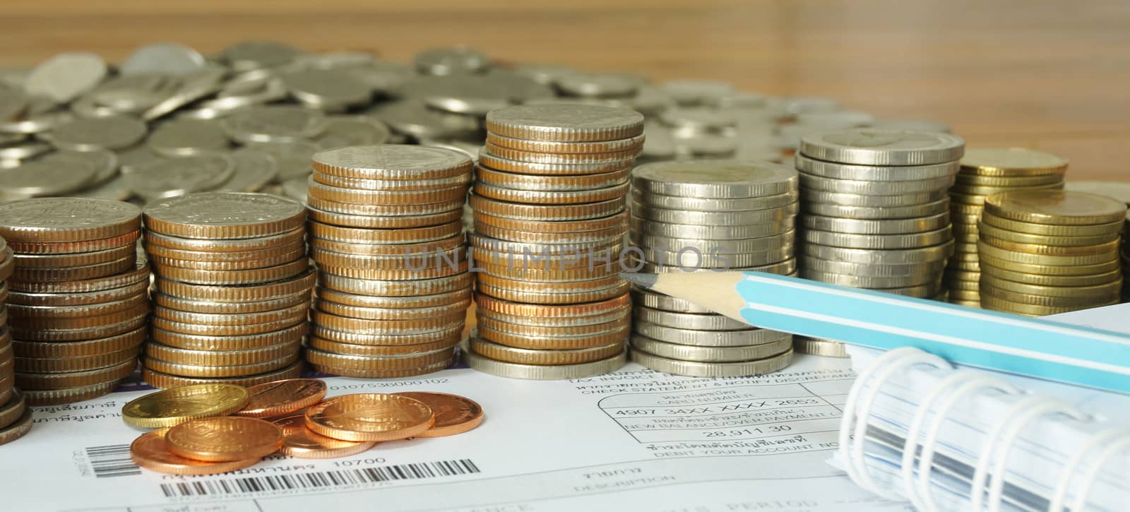 The amount of money placed on the table. A notebook and pencil to note the increase of money.                                