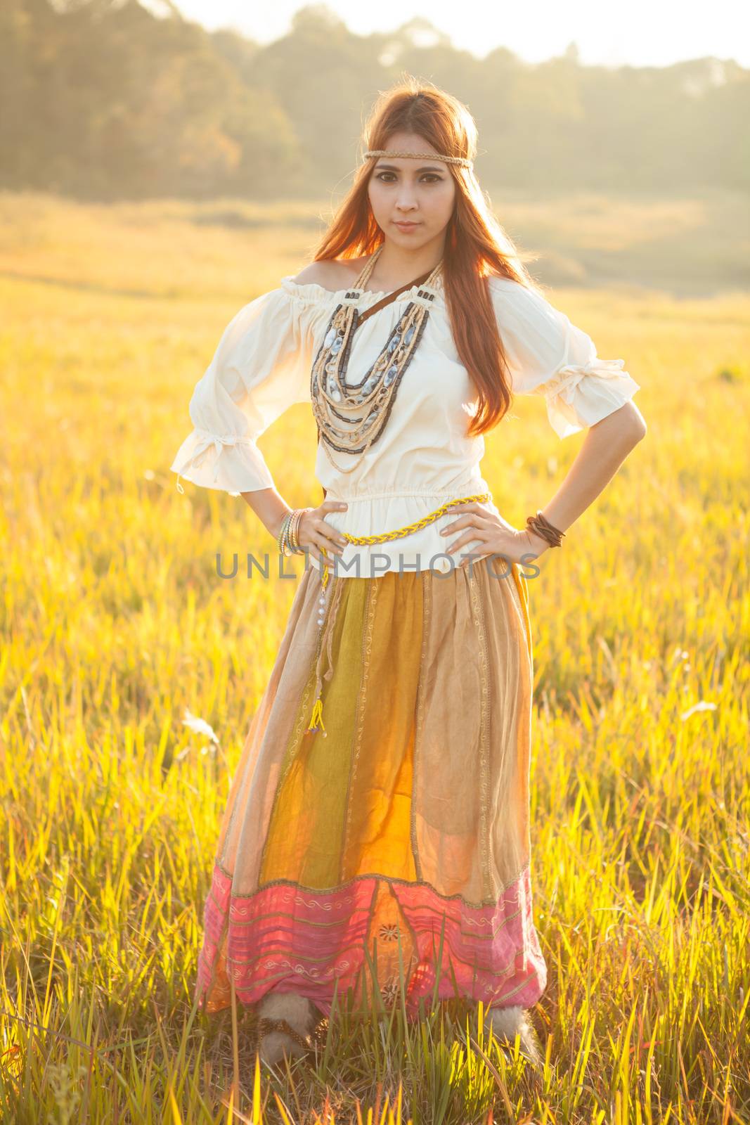 Hippie woman posing in golden field on sunset