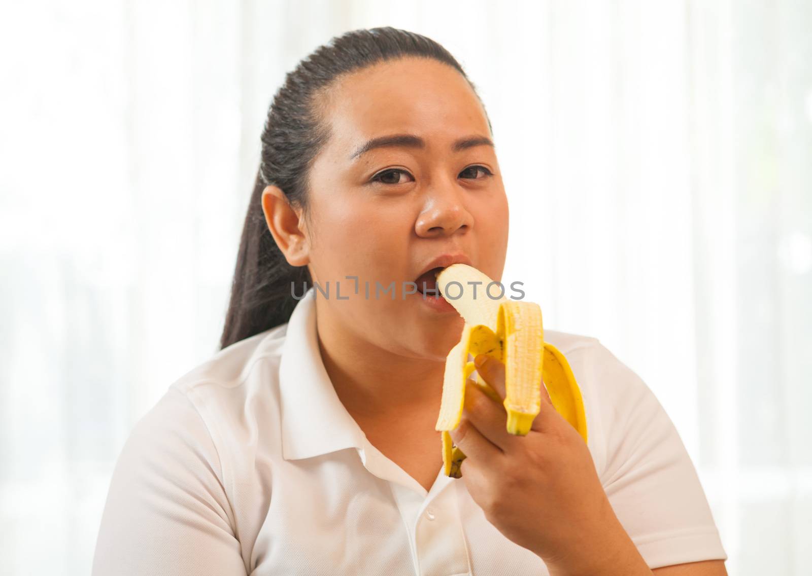 Fat asian woman with banana on white