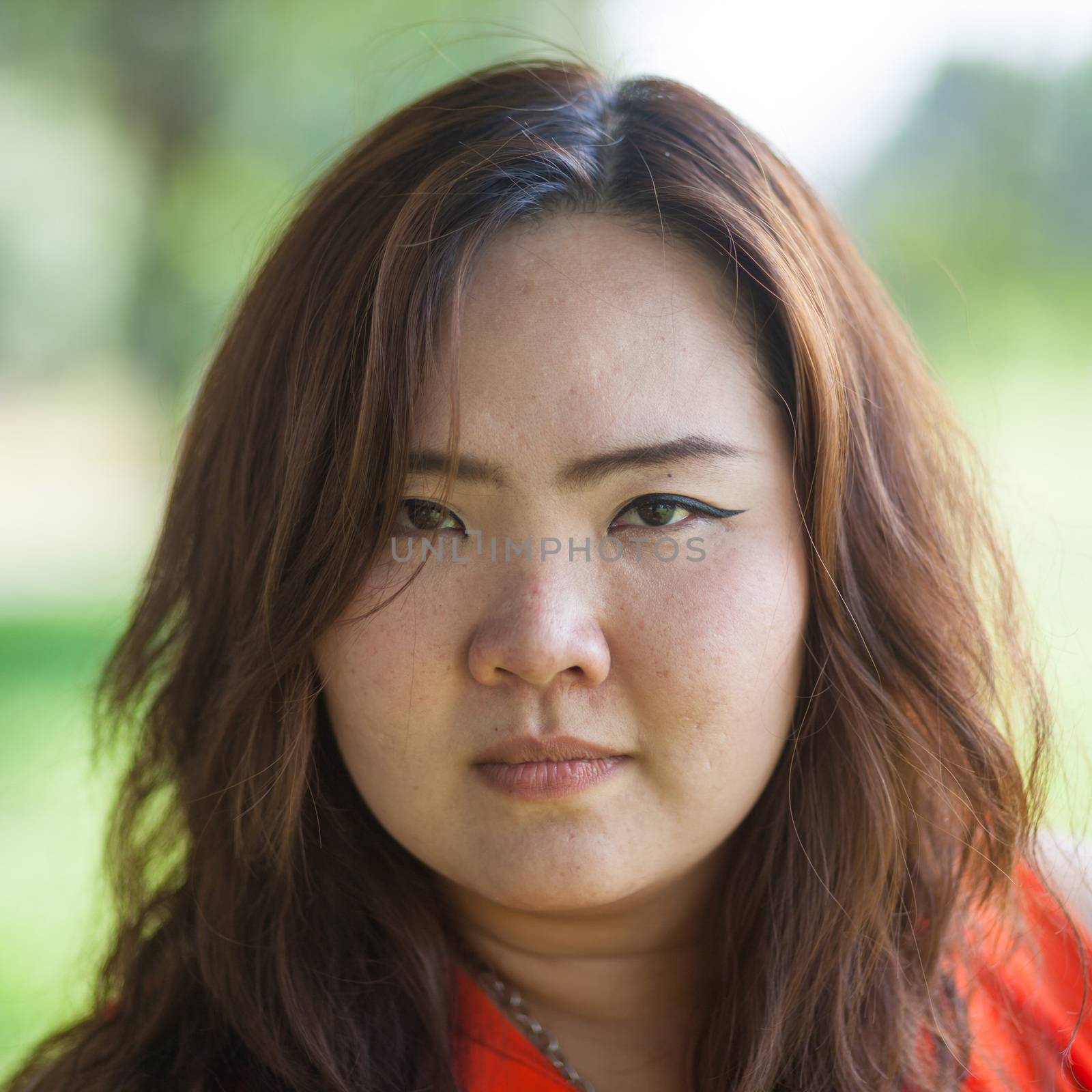 Close up of angry fatty asian woman outdoor in a park