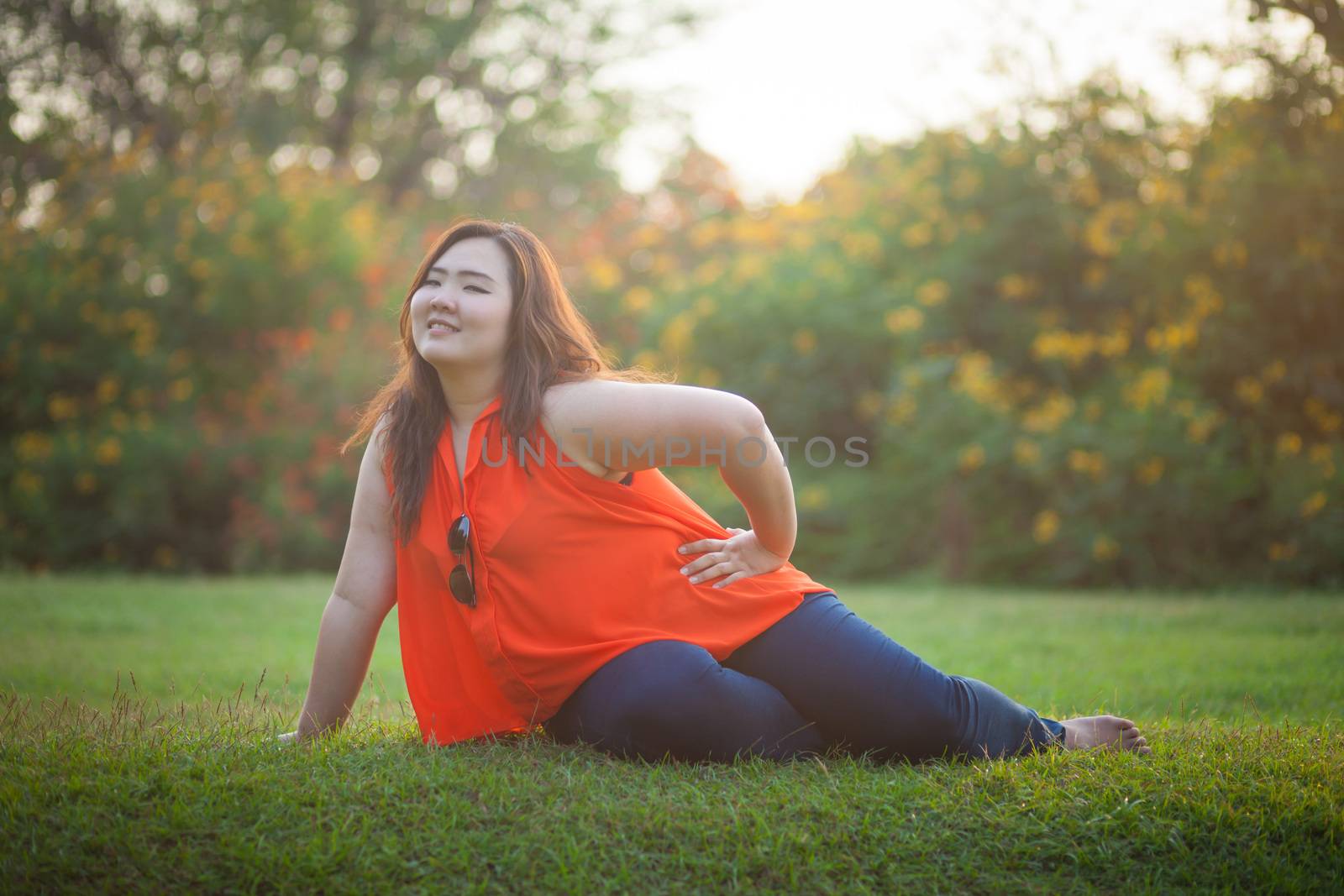 Happy fatty asian woman posing outdoor in a park