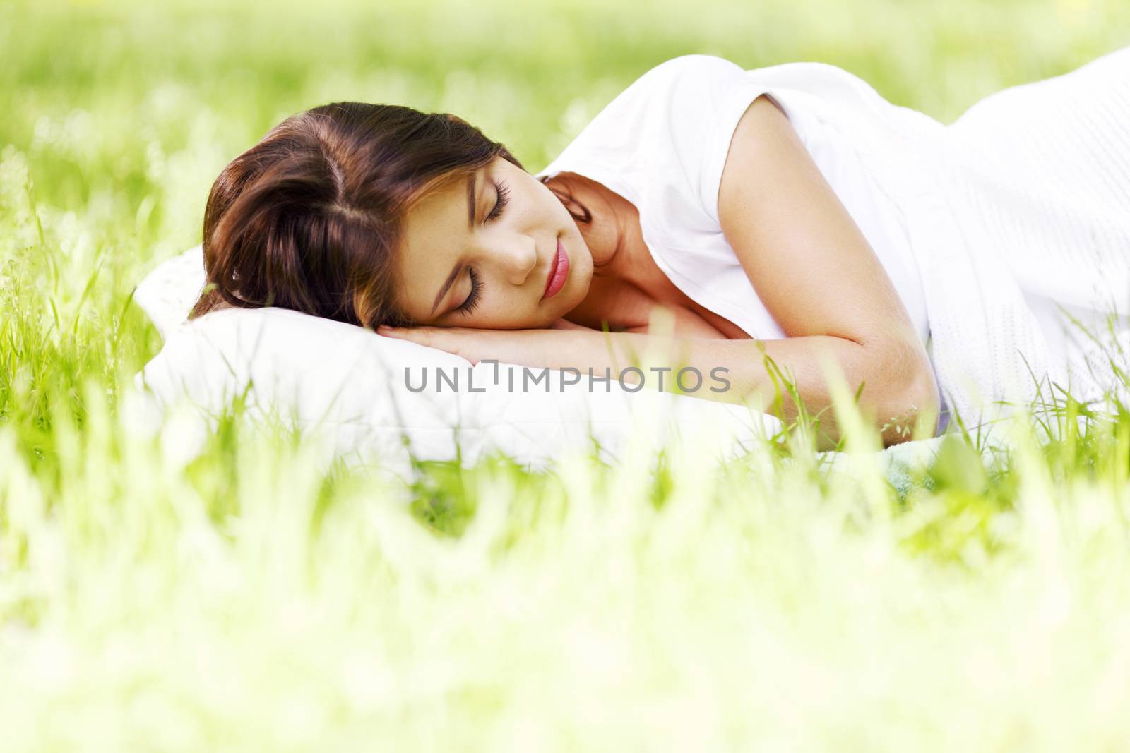 Woman sleeping on grass by Yellowj