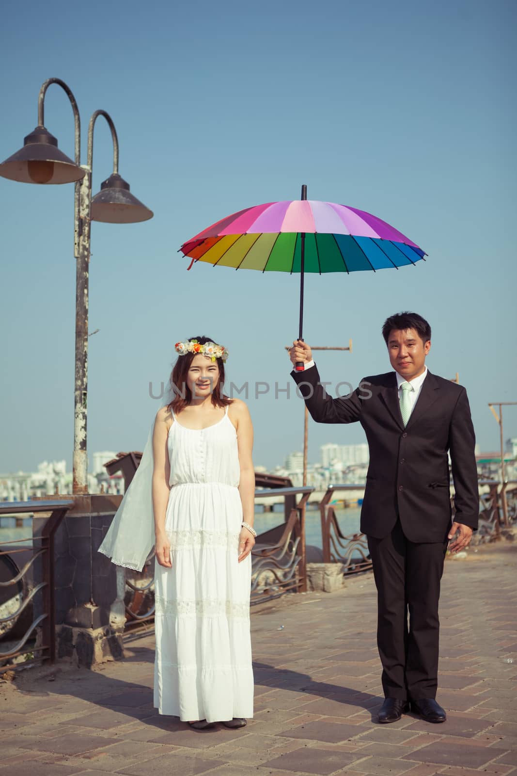 Beautiful asian couple on the beach in wedding dress