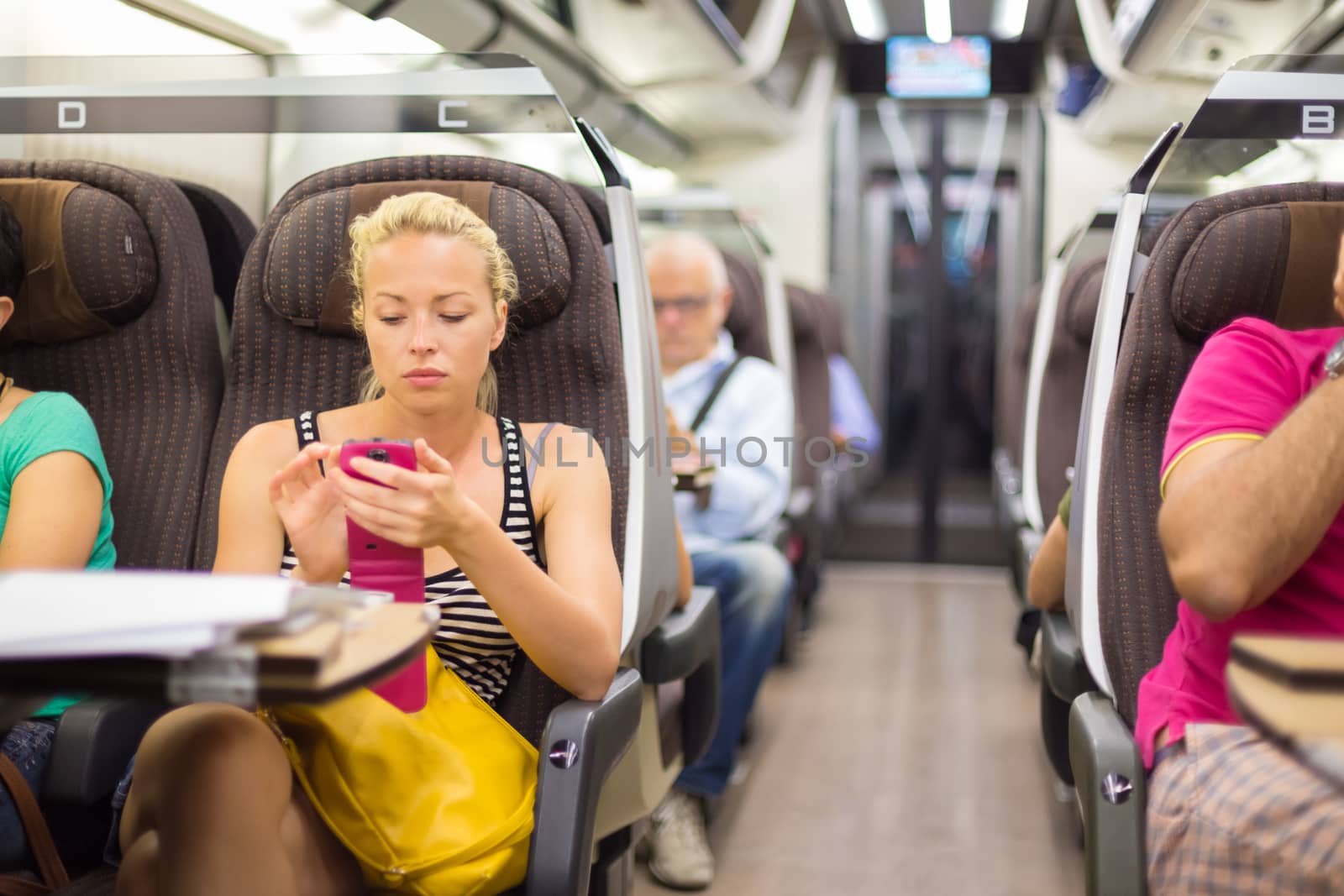 Lady traveling by train using smartphone. by kasto