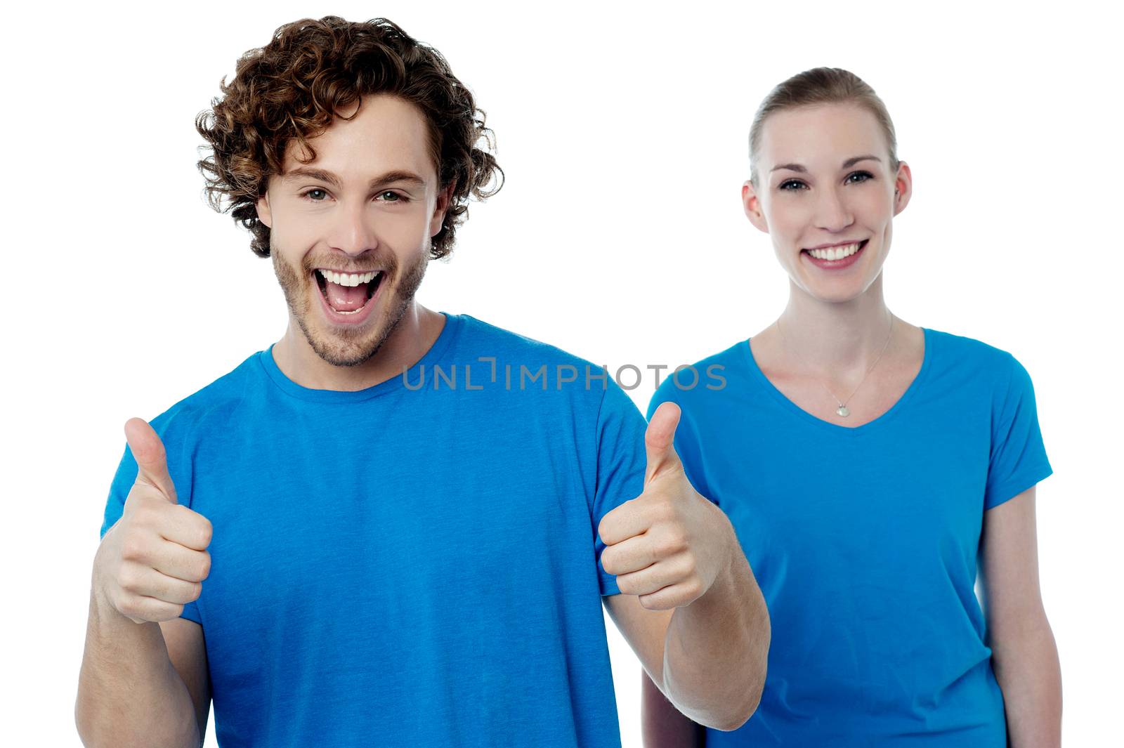 Cheerful couple holding thumbs up by stockyimages