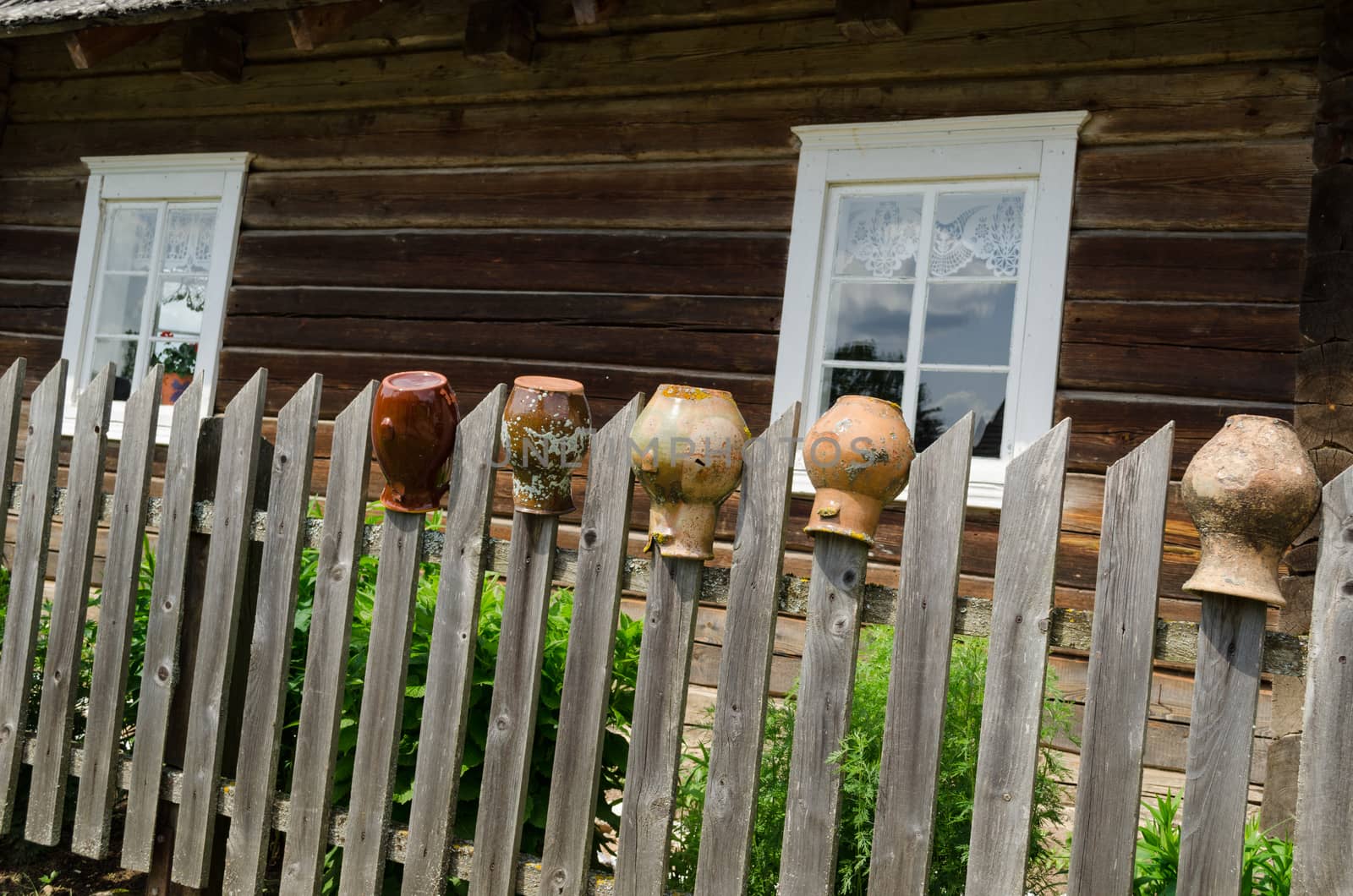 rural fence with old cracked earthen jars outdoor by sauletas