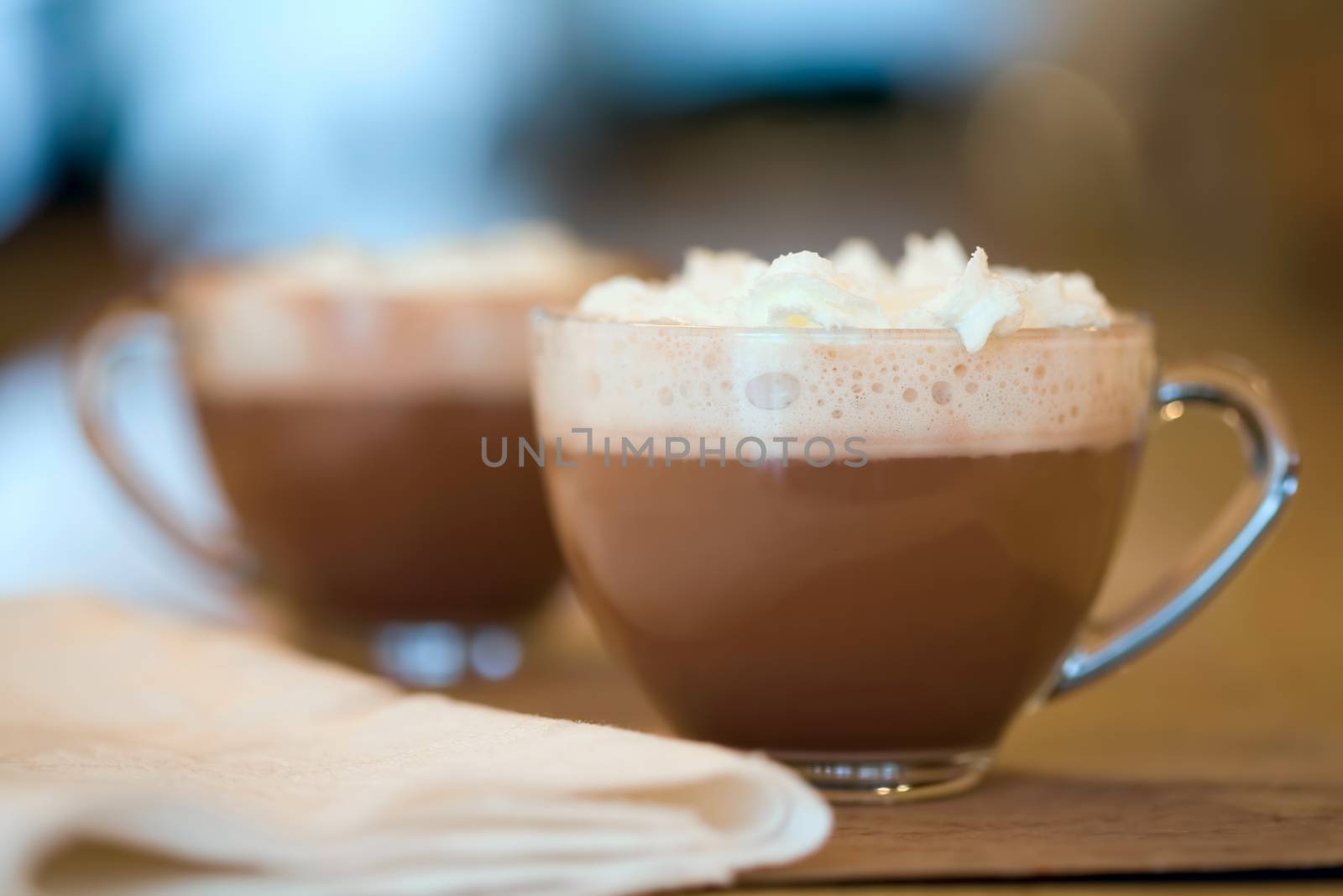 Two cups of hot cocoa or coffee on wood table background