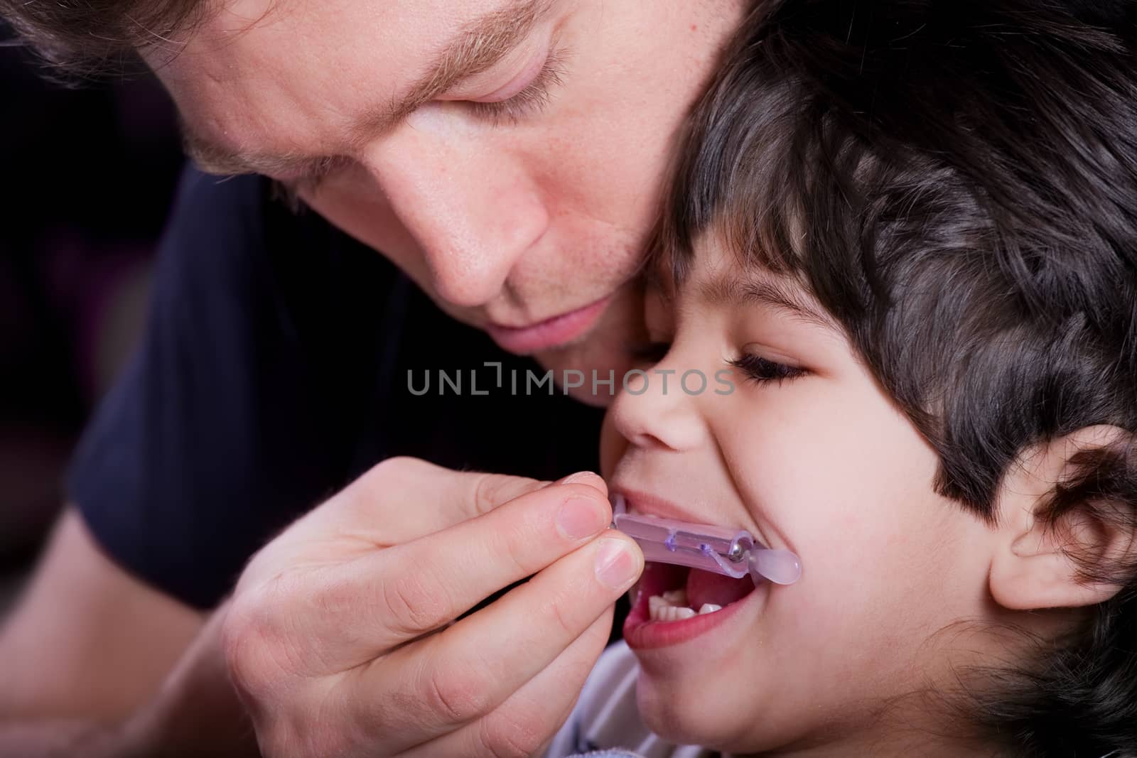 Father helping his disabled son by jarenwicklund