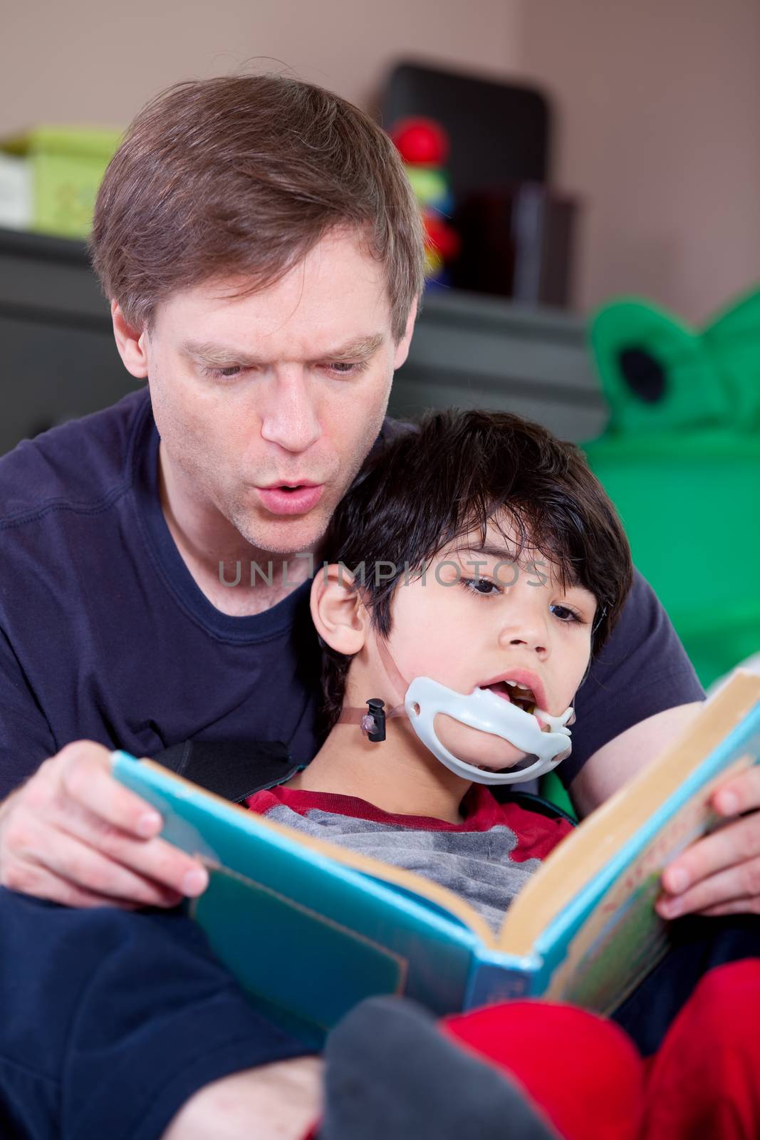 Father reading book to disabled little son by jarenwicklund