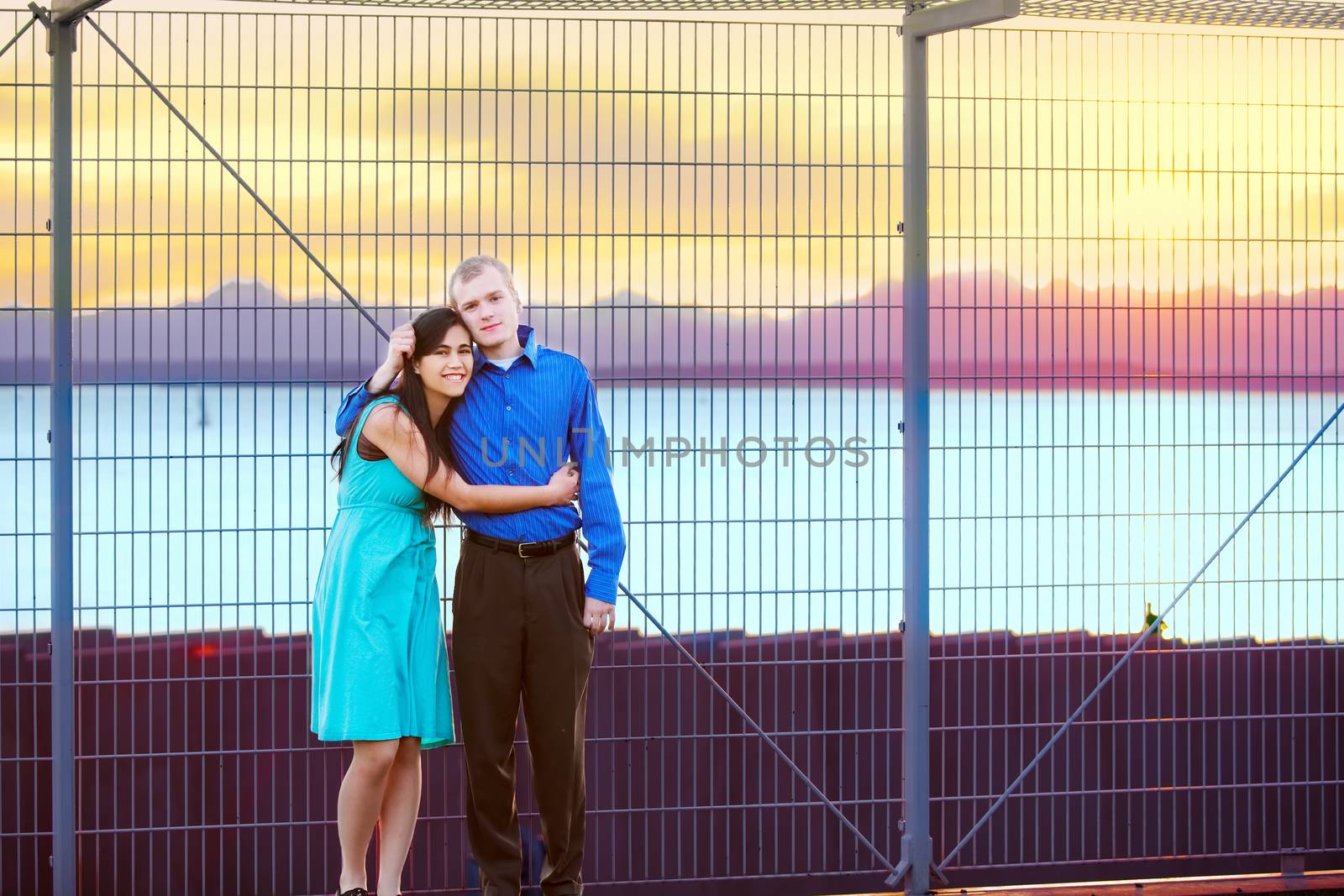 Happy interracial couple standing together outdoors at sunset