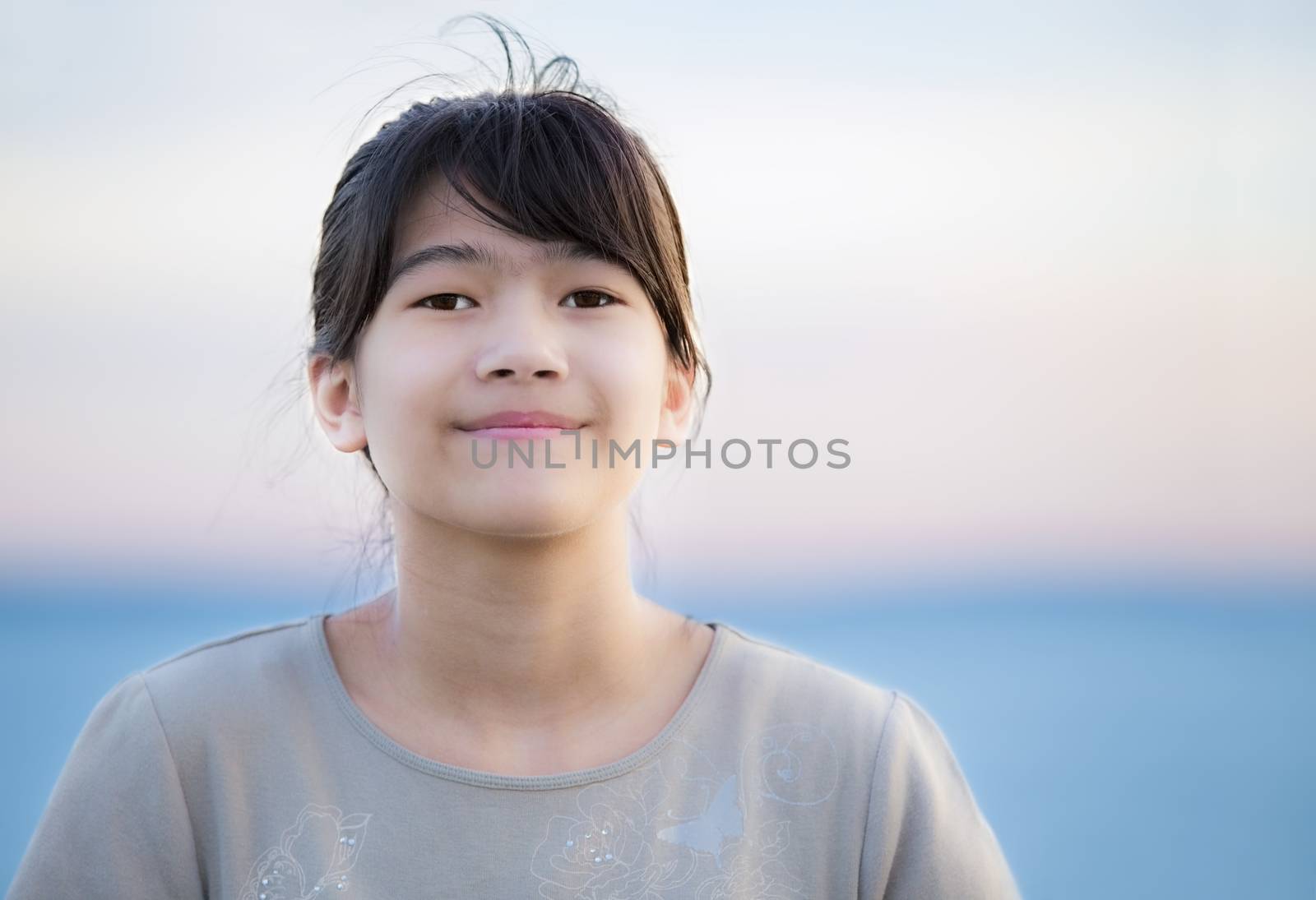Beautiful young preteen girl enjoying outdoors by lake at sunset by jarenwicklund