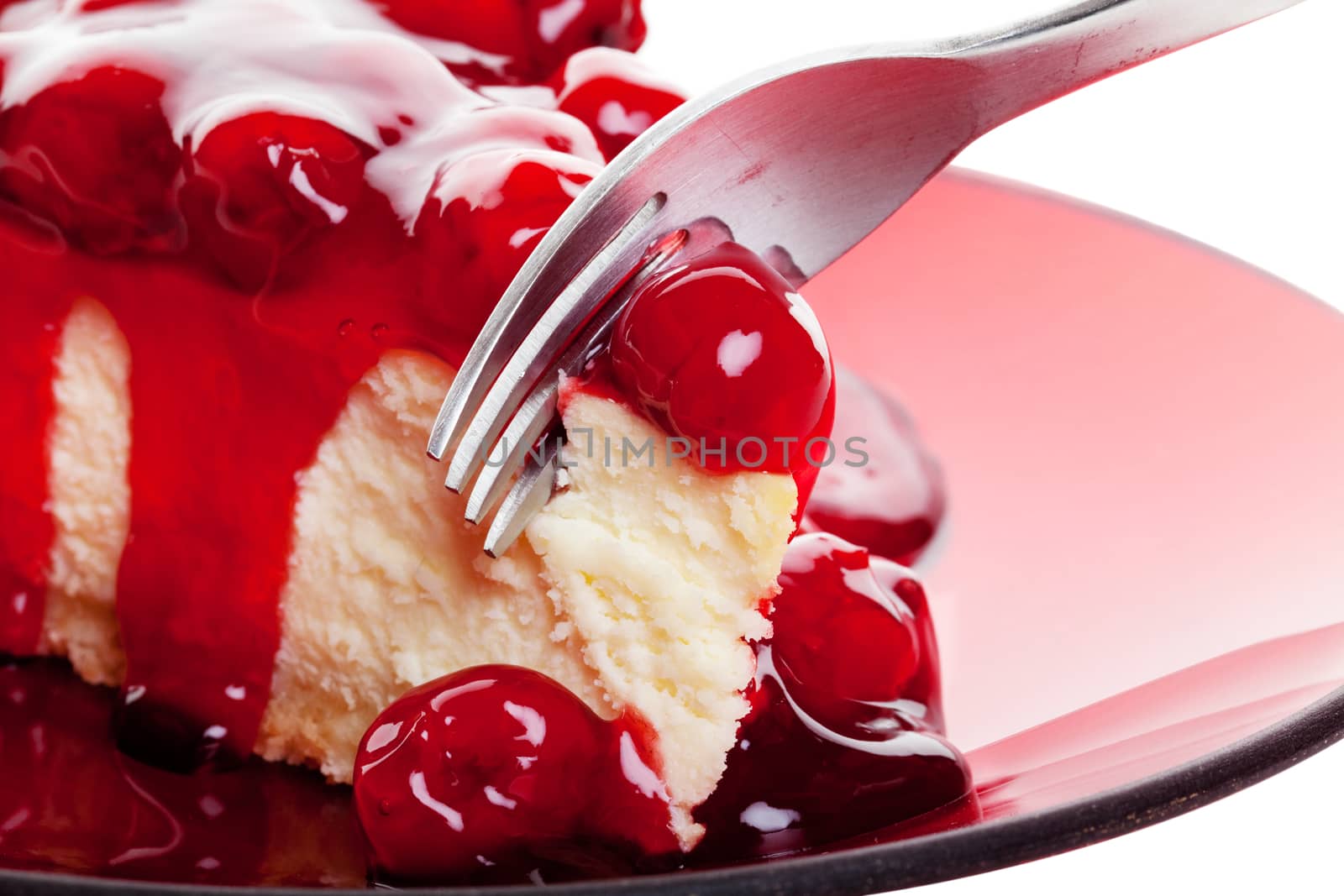 Mouth watering cherry cheesecake macro with fork.  Shot on white background.