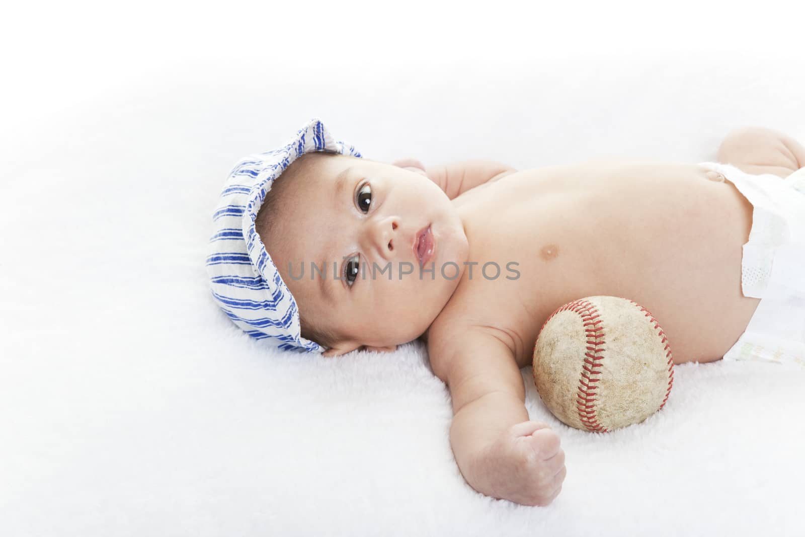 Mixed race baby boy with baseball and cap.  Future baseball player.