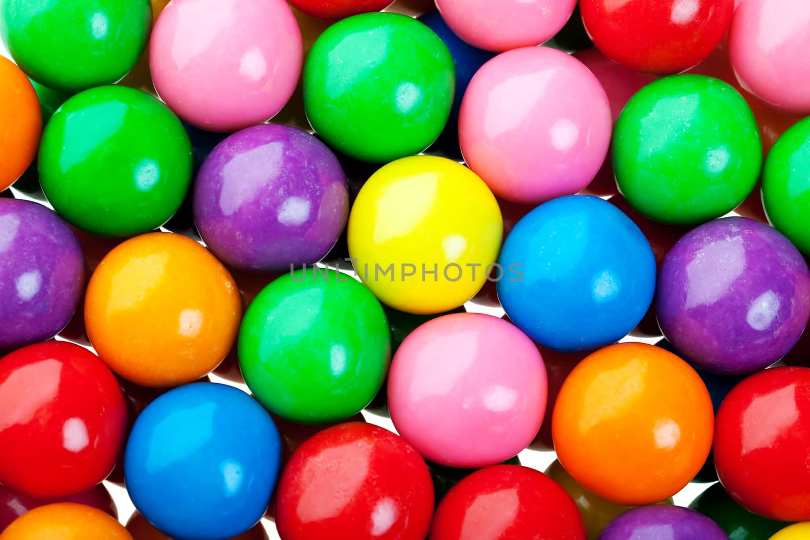 A colorful background of candy coated gumballs.
