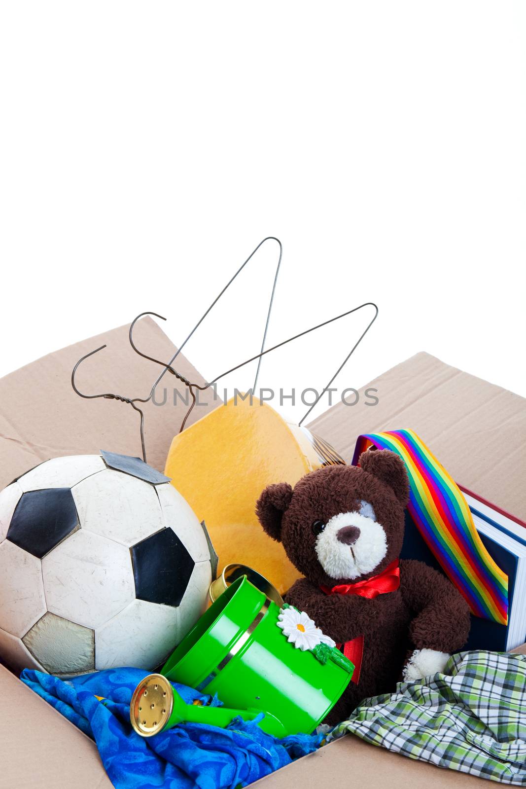 A box of unwanted stuff ready for a garage sale or to donate to a charitable organization.  Generic teddy bear.  Shot on white background.