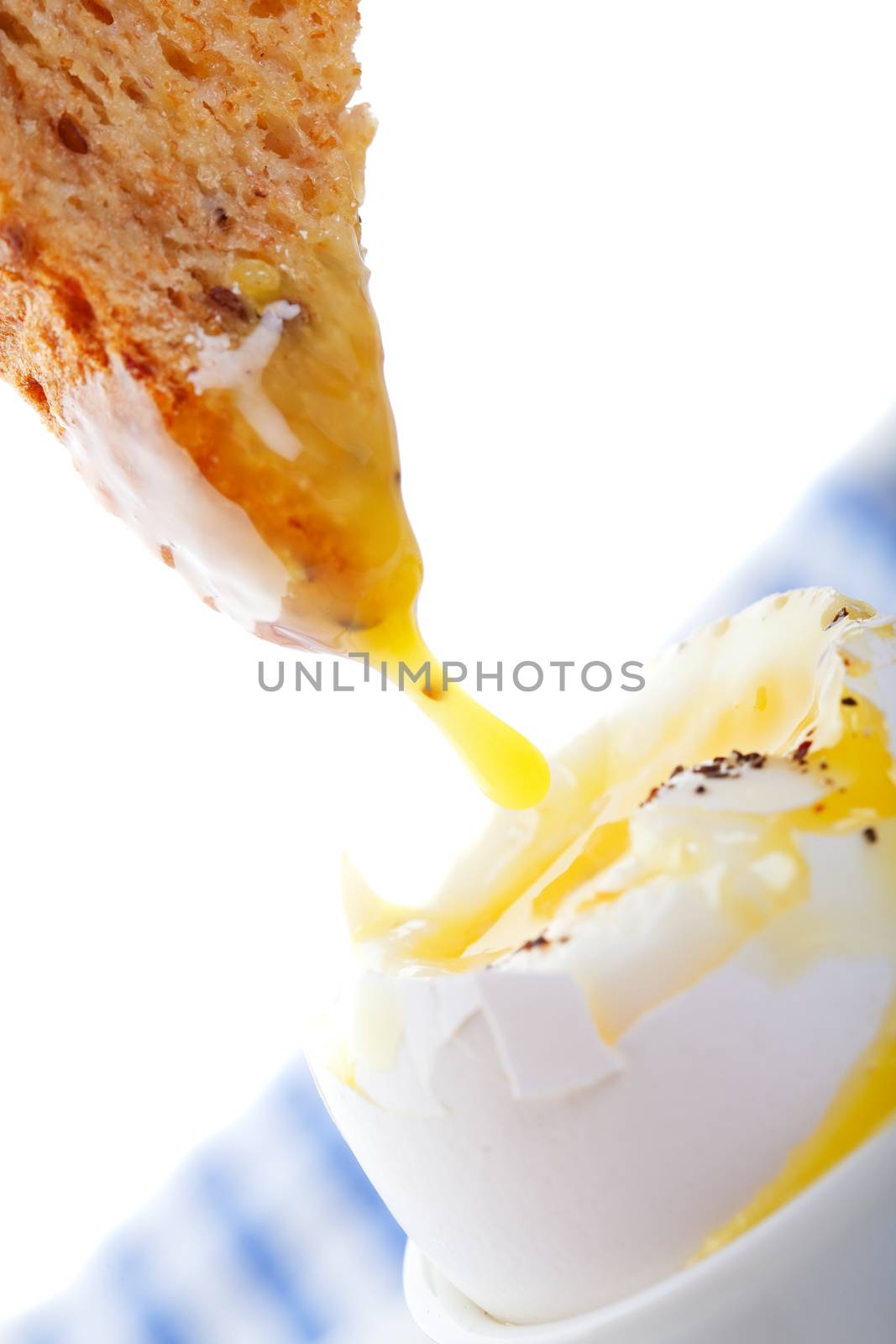 Soft-Boiled egg with toast dripping in yolk.  A popular European breakfast.