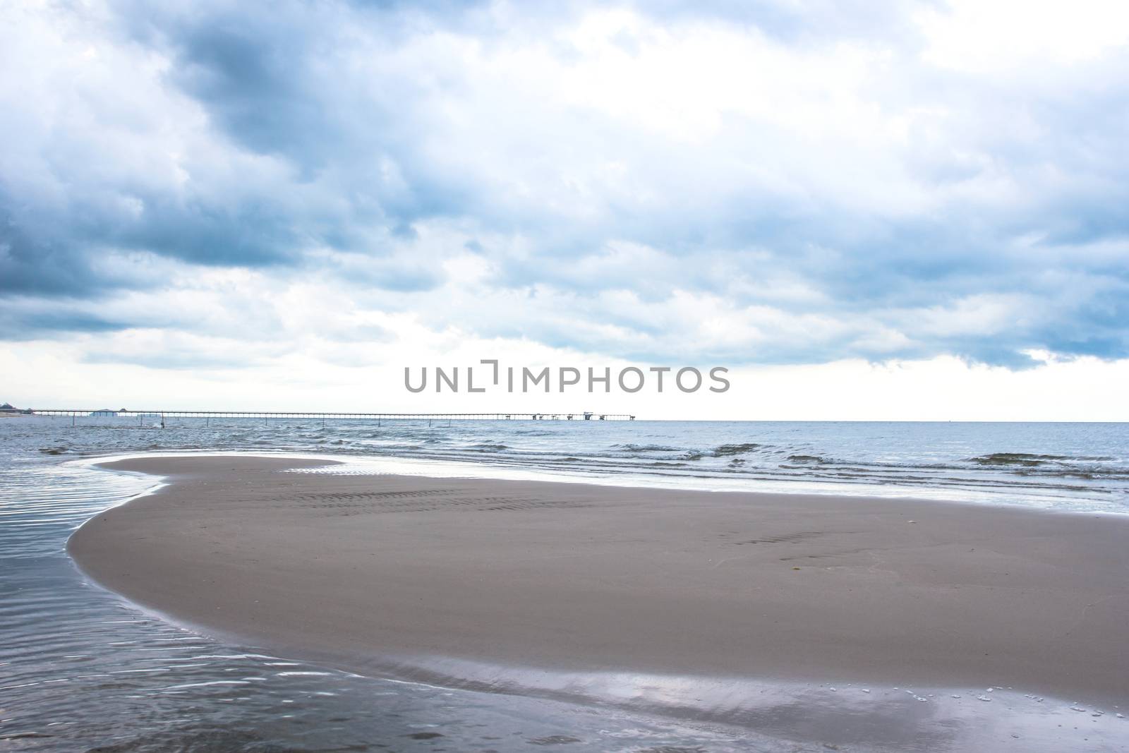Stormy sky over dark sand and sea by kannapon