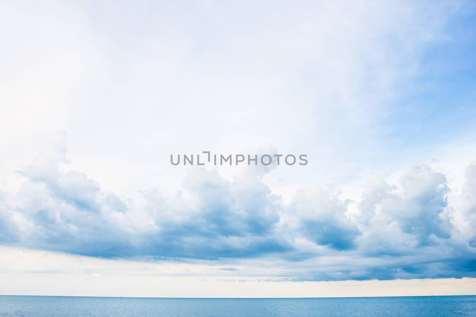 blue sea and cloudy sky over it by kannapon