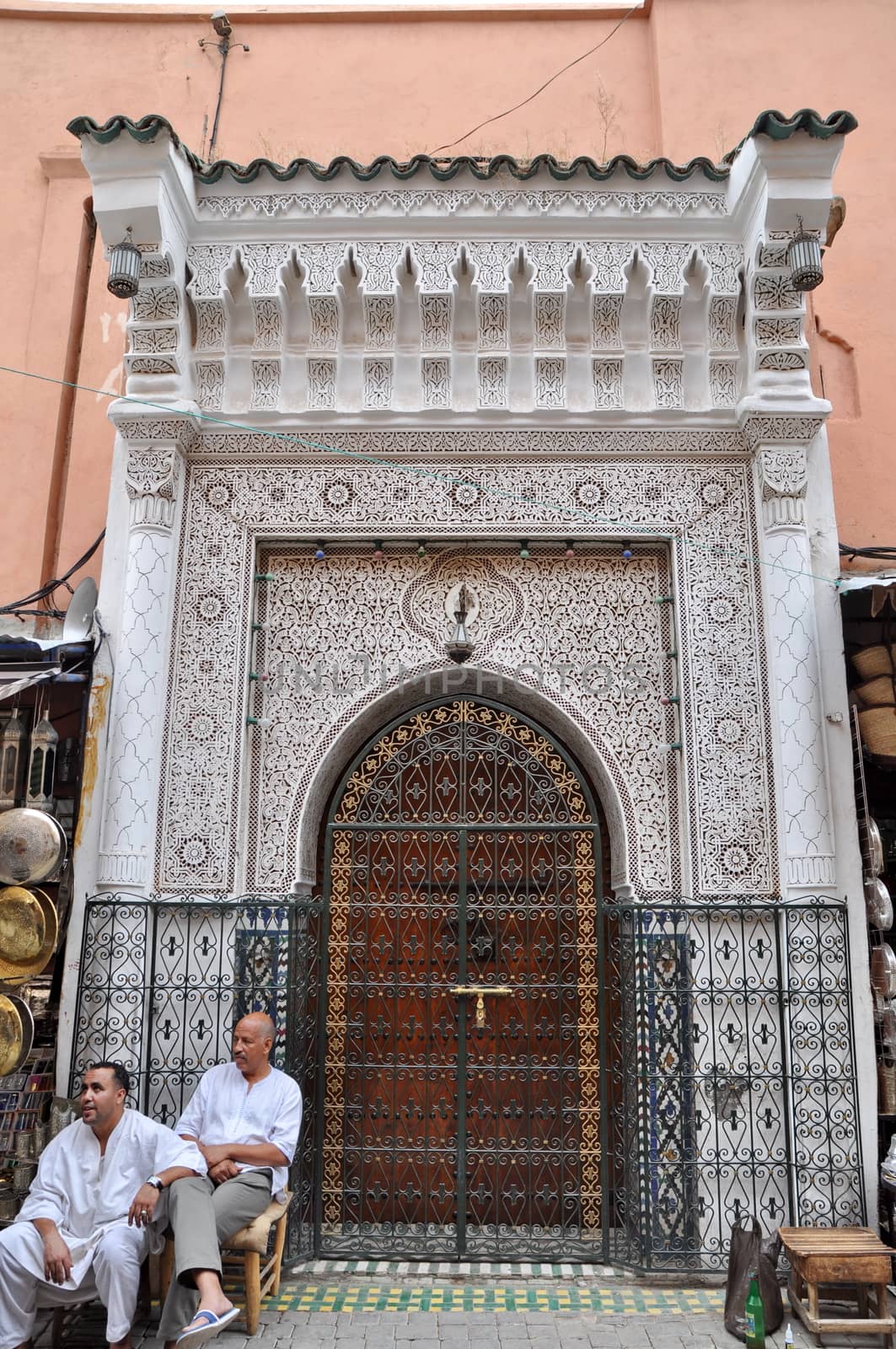 MARRAKECH - SEPTEMBER 23: Local people sitting at a beautiful handmade entrance. In Marrakech, Morocco, September 23, 2013.