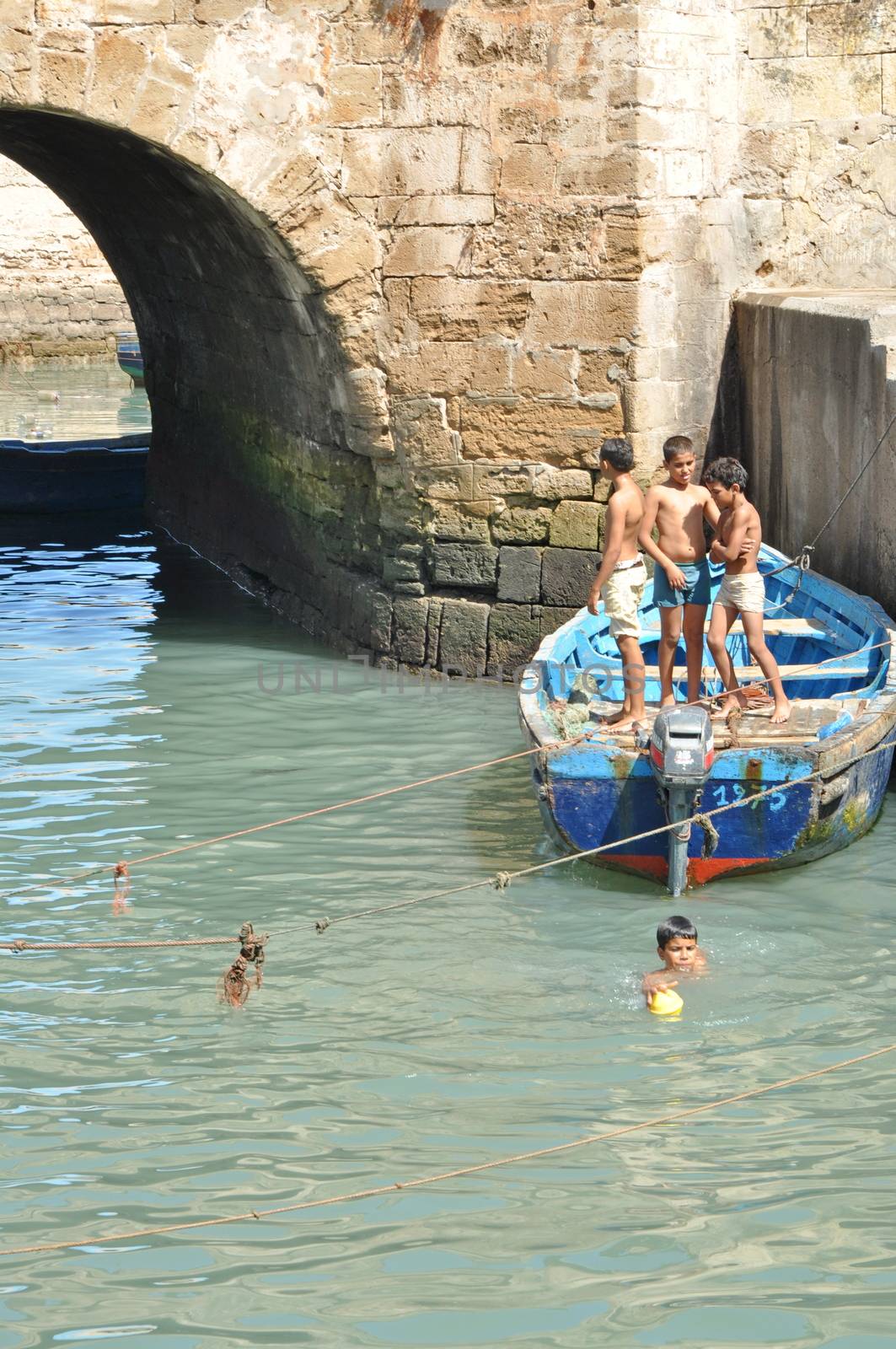 ESSAOUIRA - SEPTEMBER 29: Children take a bath in the canal. Ess by anderm