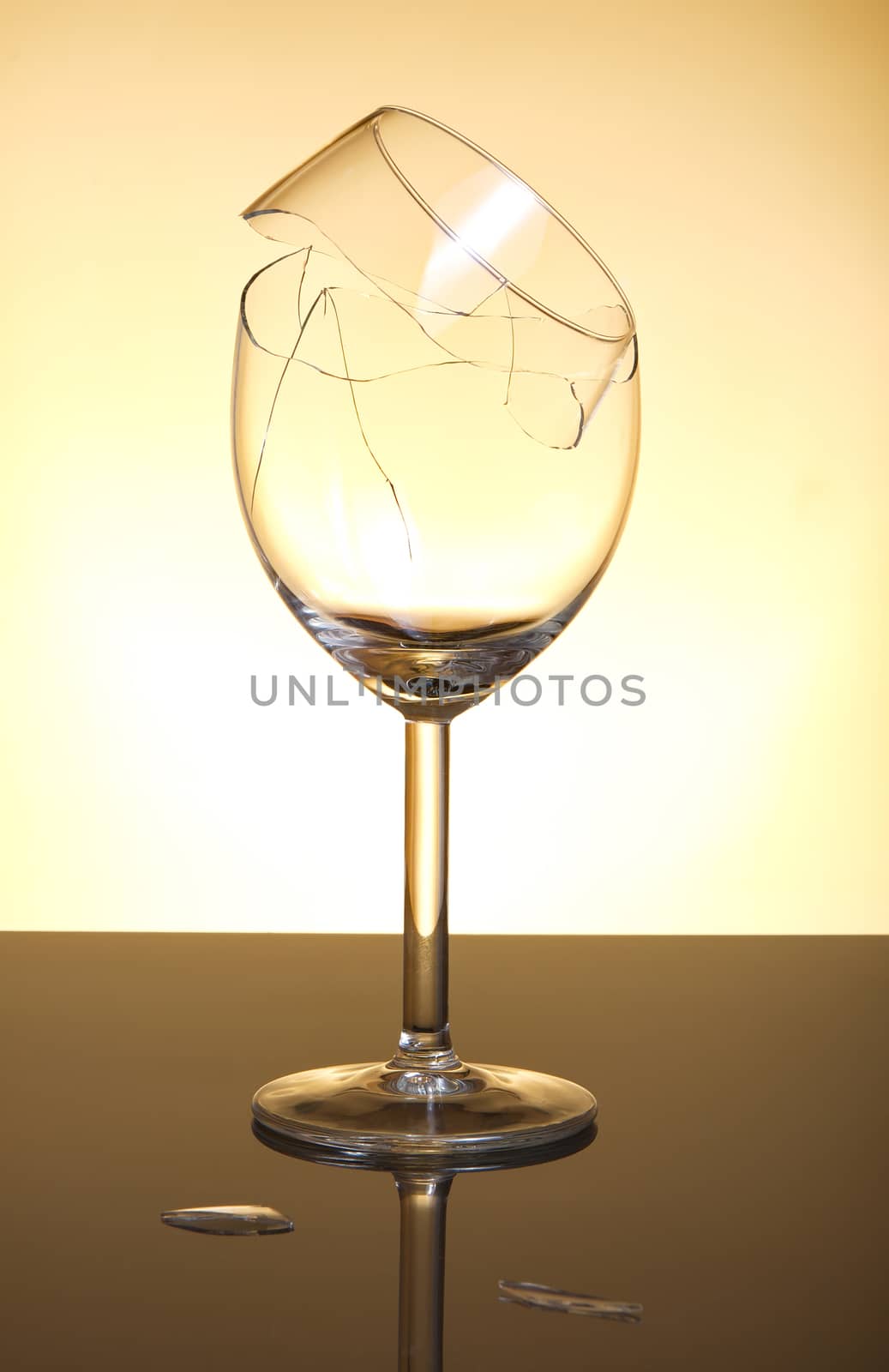 Broken vine glass on orange background by anderm