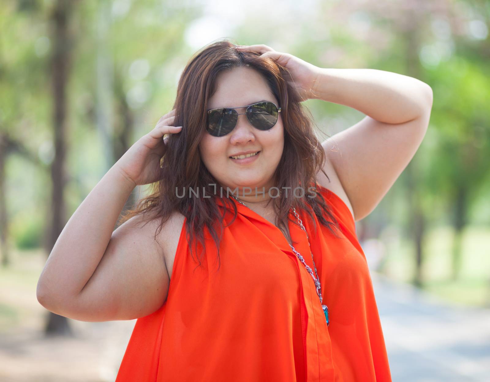 Close up of happy fatty asian woman outdoor in a park