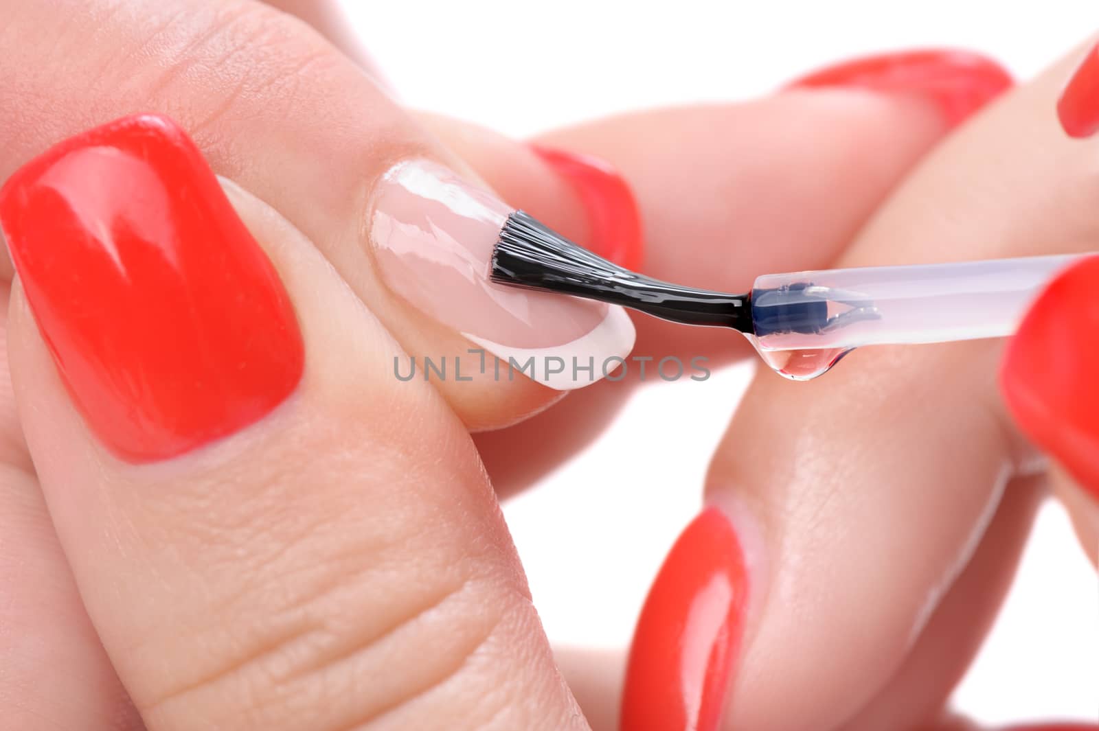 manicure applying, brushing fingernails with clear enamel