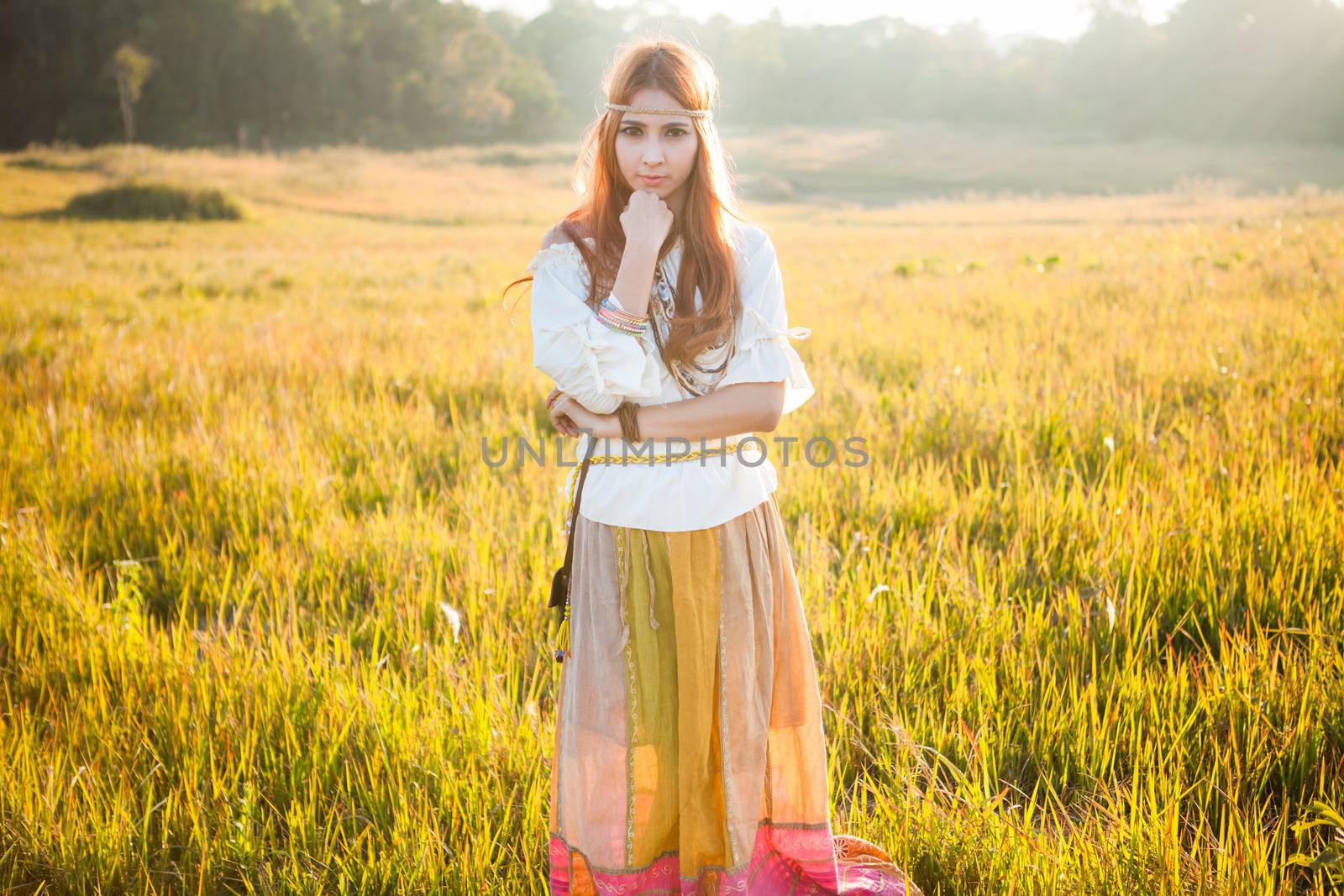 Hippie woman posing in golden field on sunset