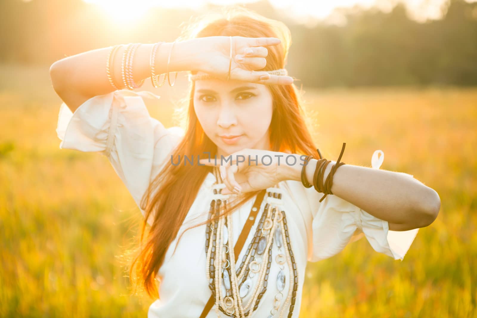 Hippie woman posing in golden field on sunset