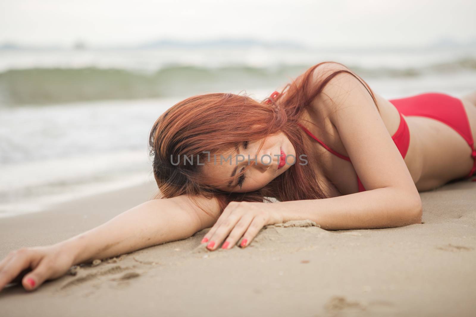 Beautiful asian woman in red bikini posing at beach