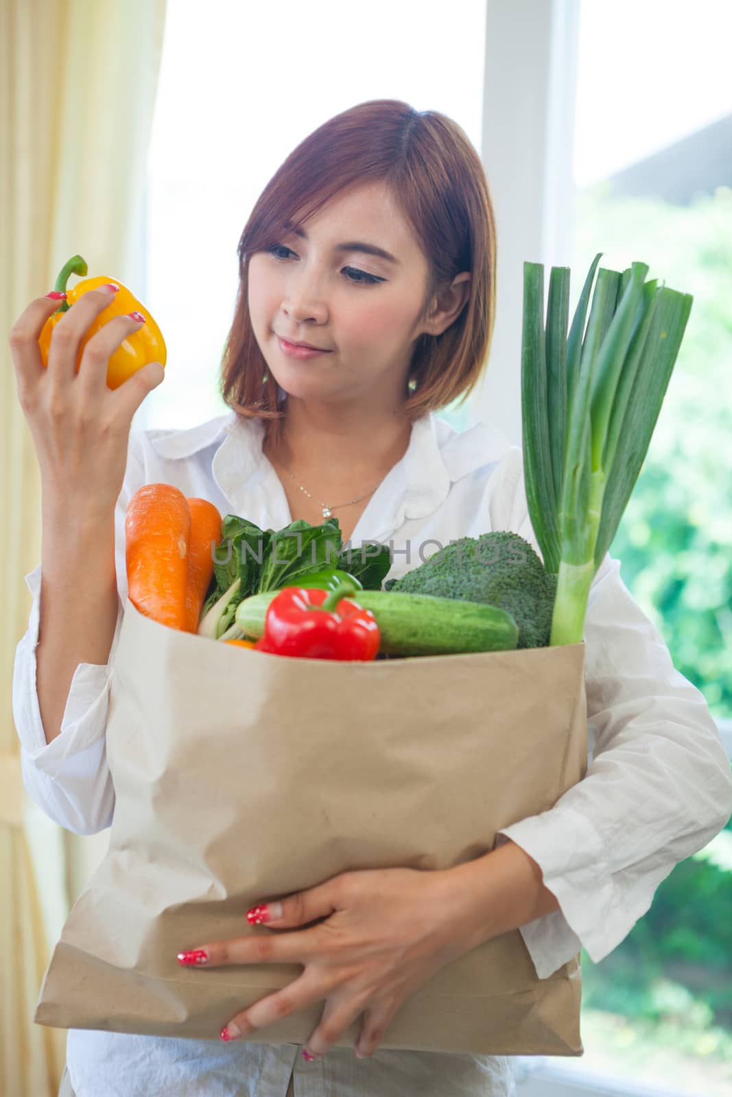 Happy Young Asian Woman with vegetables in shopping bag