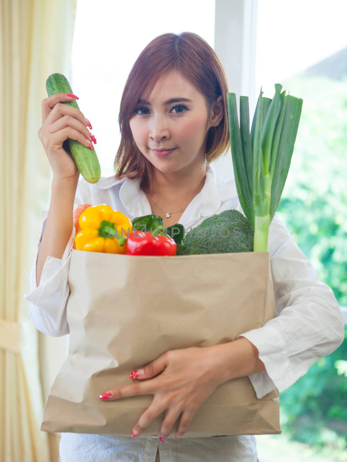 Happy Young Asian Woman with vegetables in shopping bag