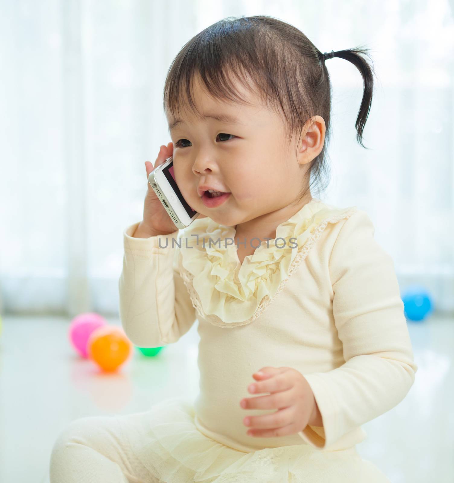 Portrait of pretty asian little girl talking on mobile phone