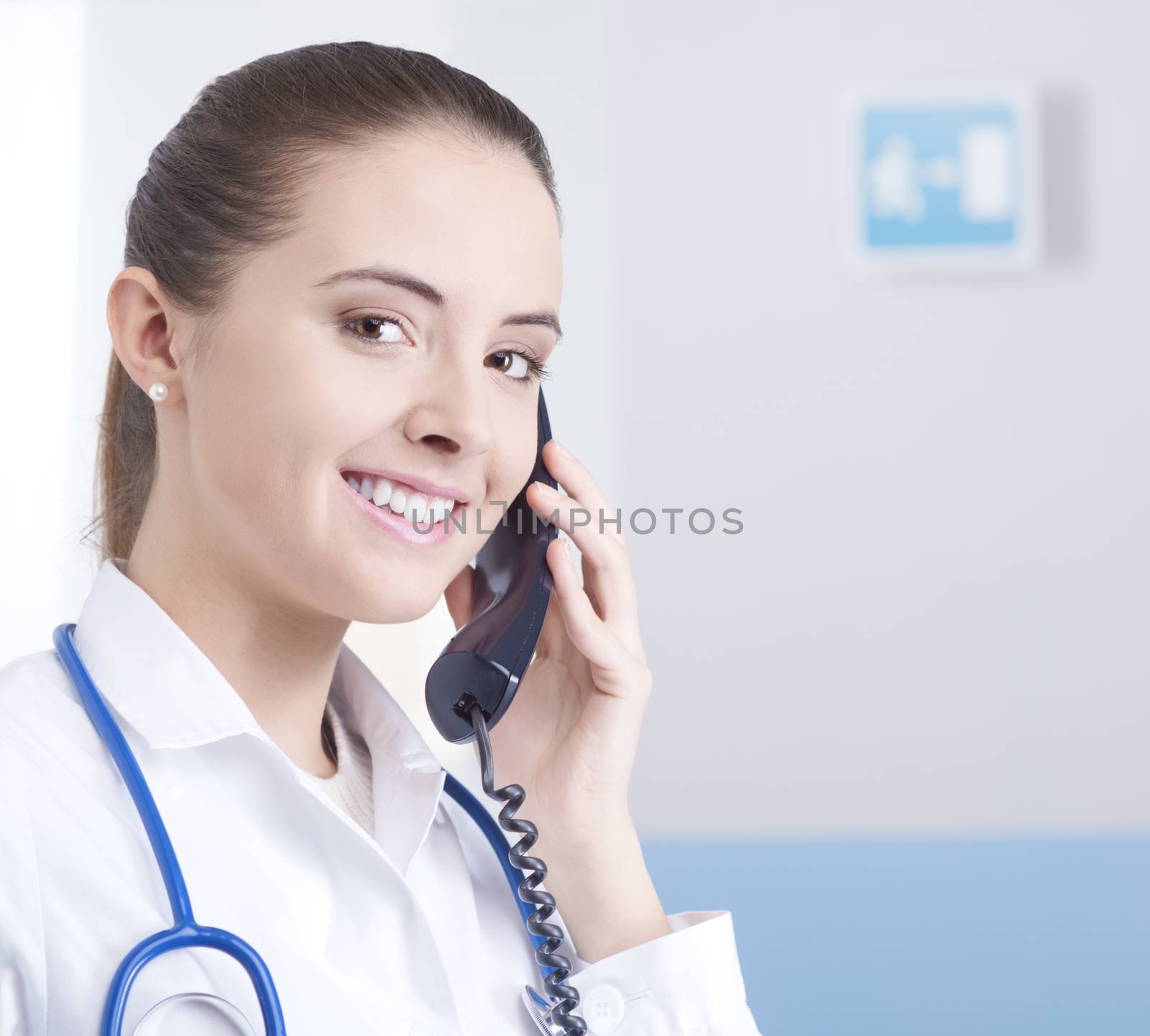 Young female doctor talking on the phone and smiling