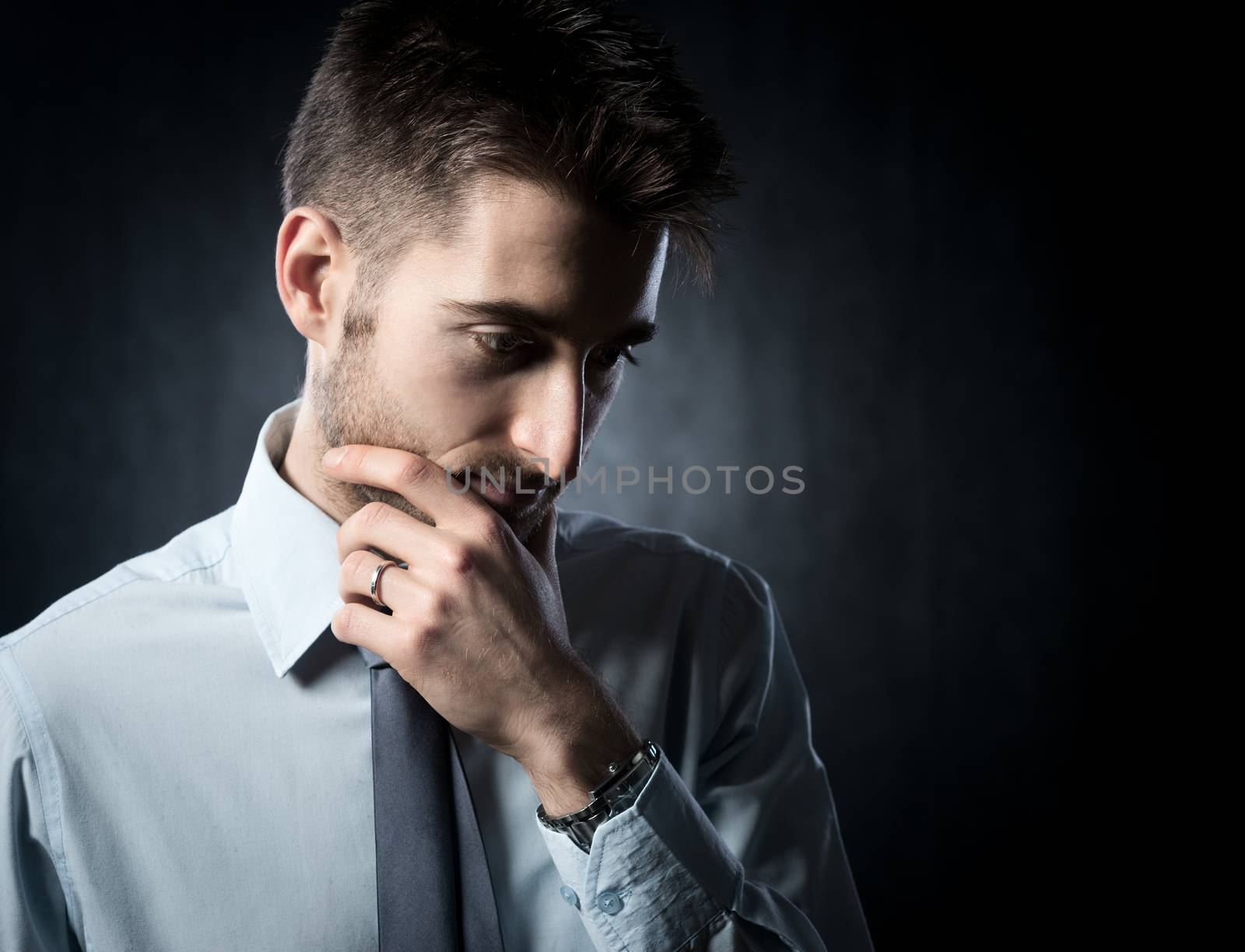 Young attractive businessman thinking with pensive expression.