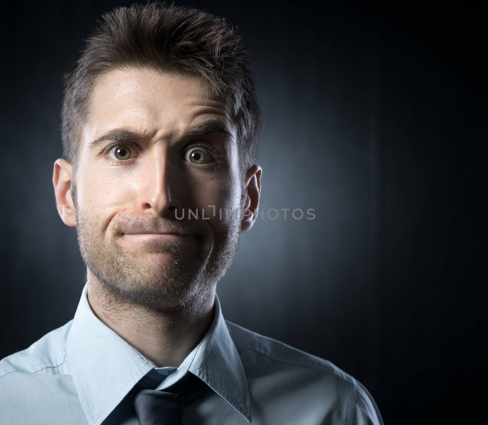 Young businessman: confused expression with raised eyebrow.