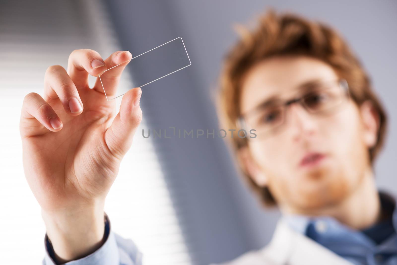 Researcher holding microscope slide by stokkete