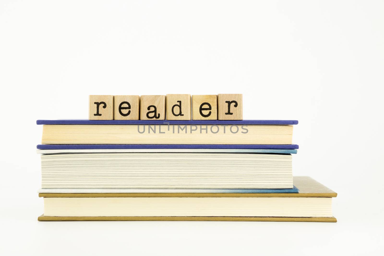 reader word on wood stamps stack on books, library and education concept