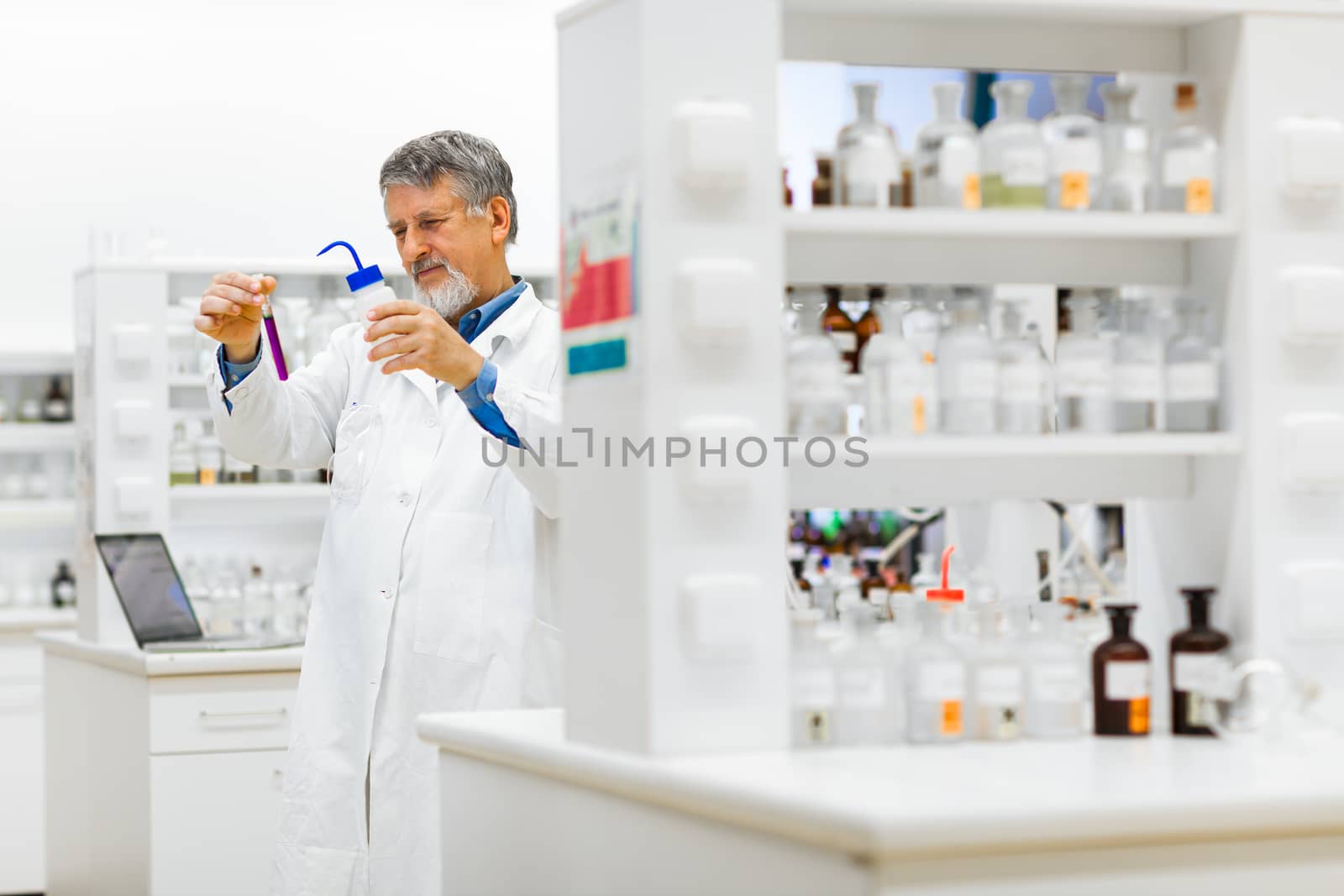 Senior male researcher carrying out scientific research in a lab (shallow DOF; color toned image)