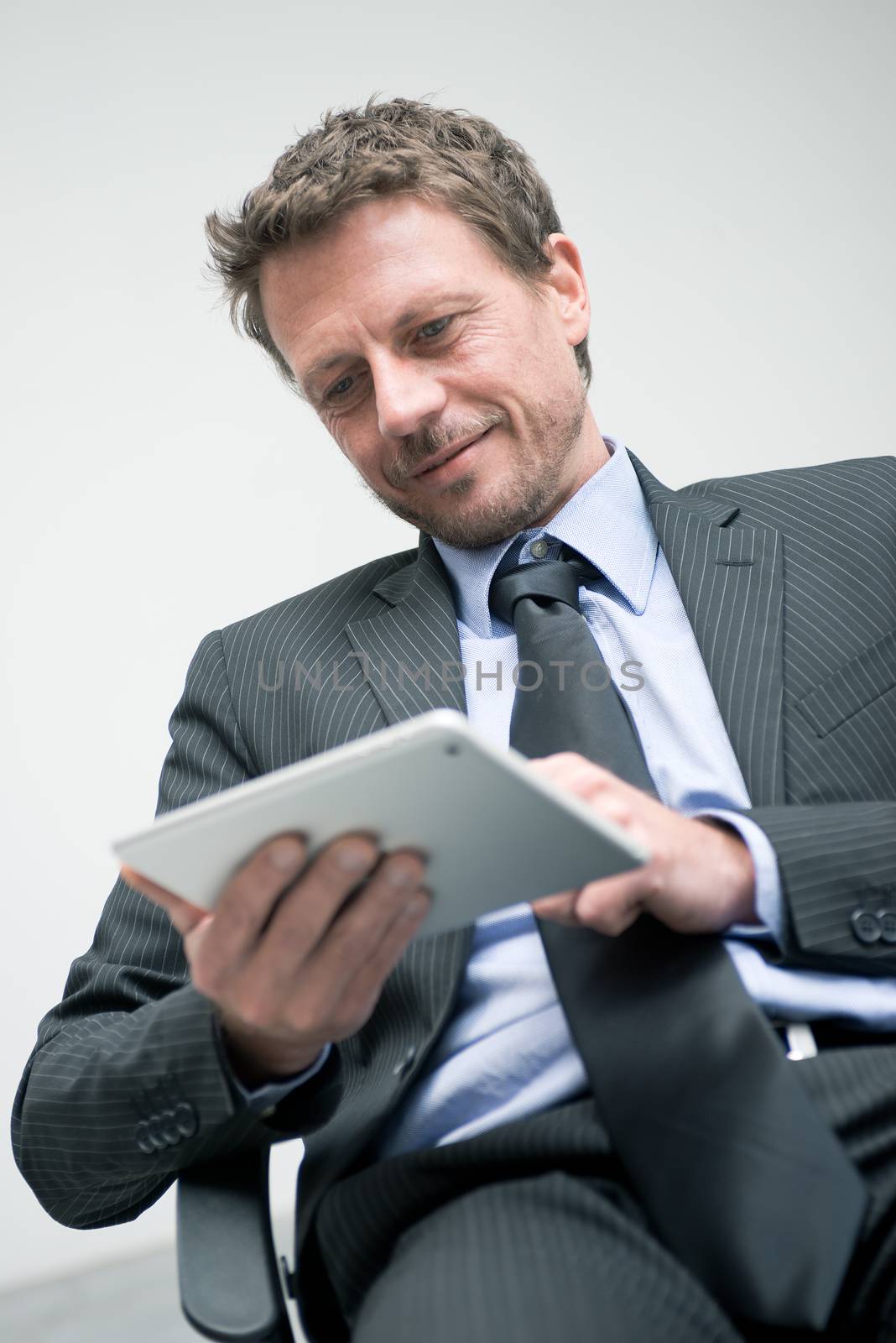Attractive businessman working with tablet and touching digital display.