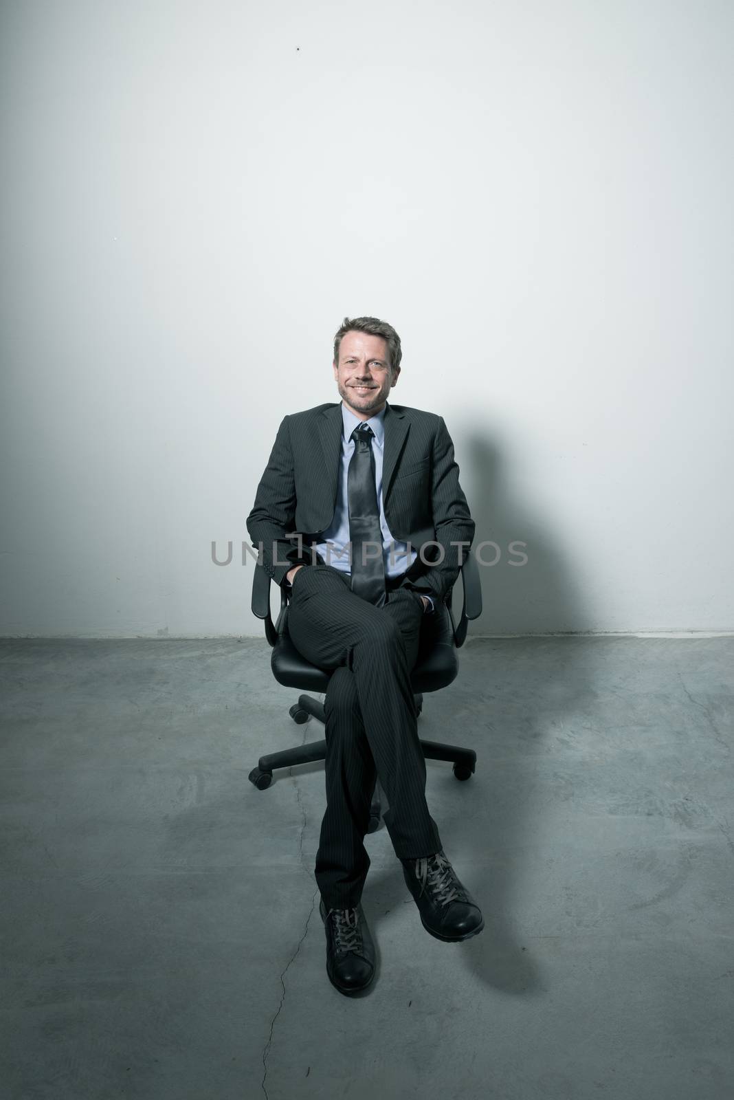 Businessman sitting on an office chair by stokkete