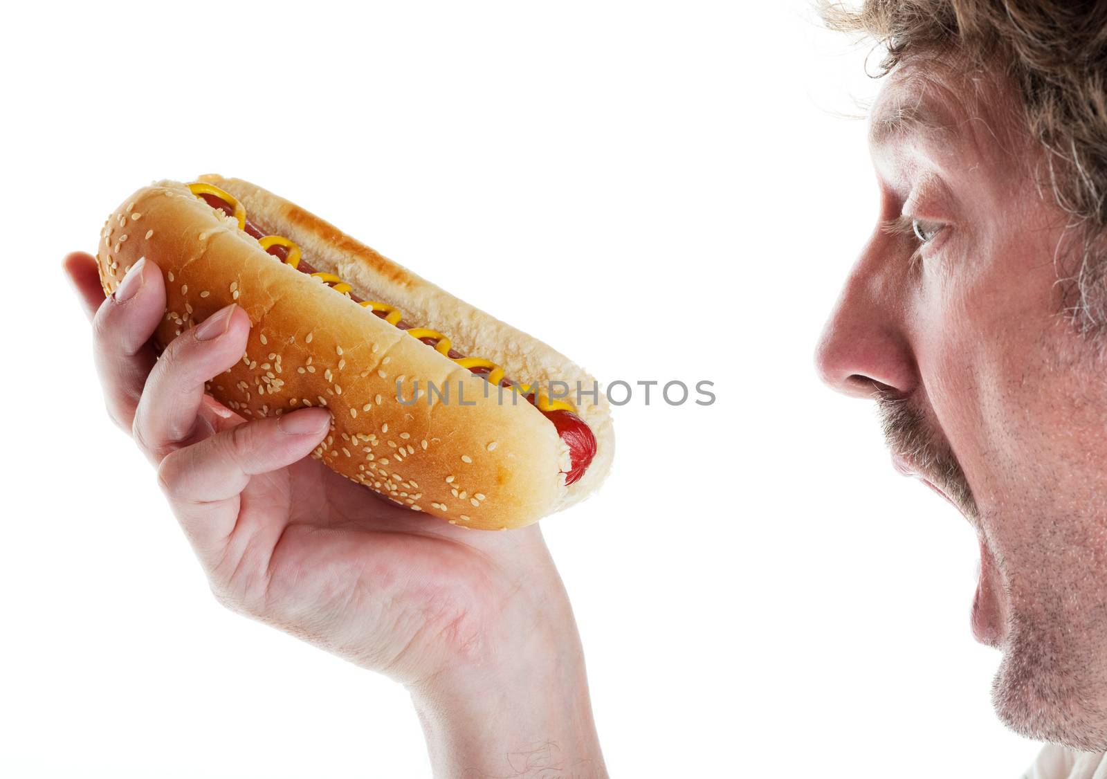 A hungry man can't wait to take a big bite of his delicious hot dog.