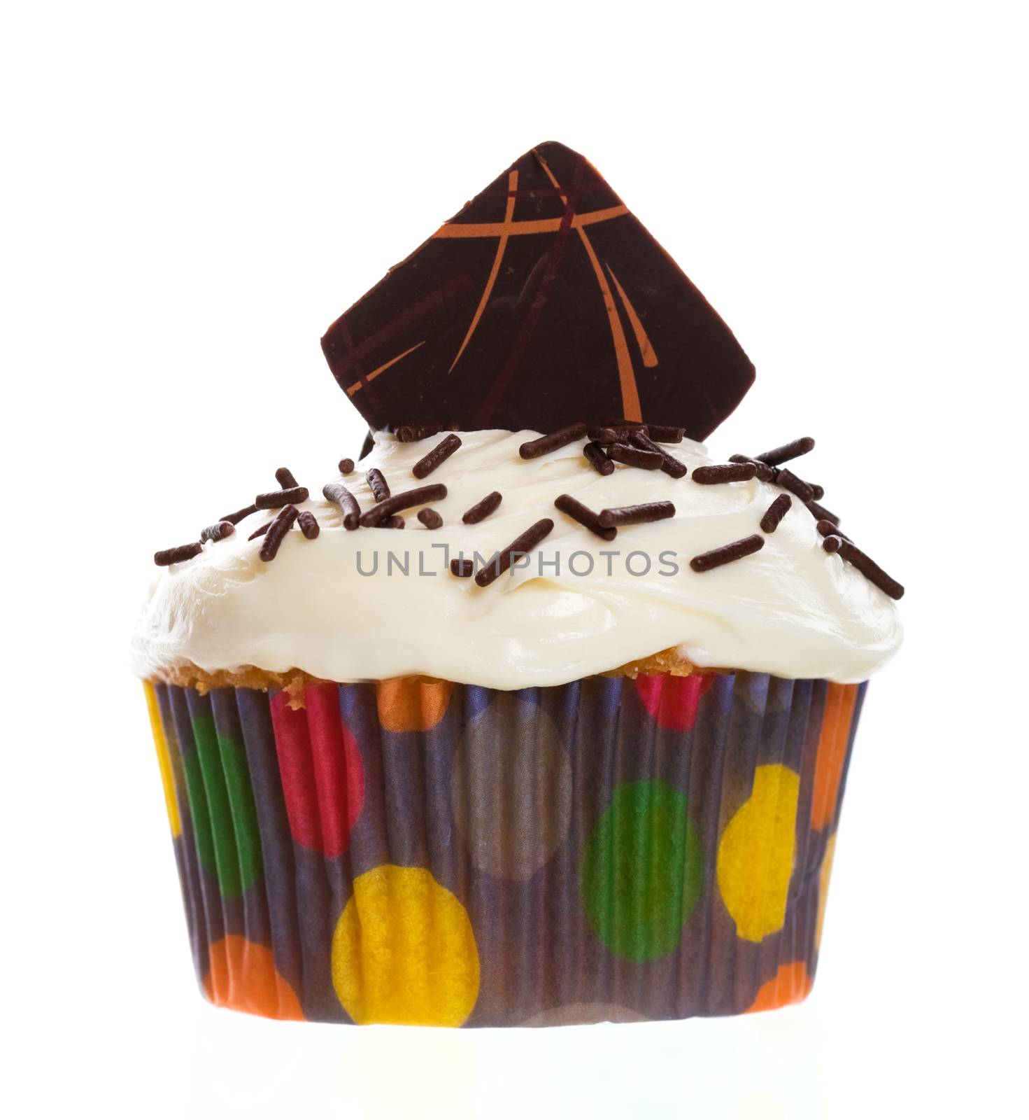 A decadent vanilla cupcake with white icing, decorated with chocolate sprinkles and crowned with a dark chocolate wafer with streaks of milk chocolate.  Shot on white background.