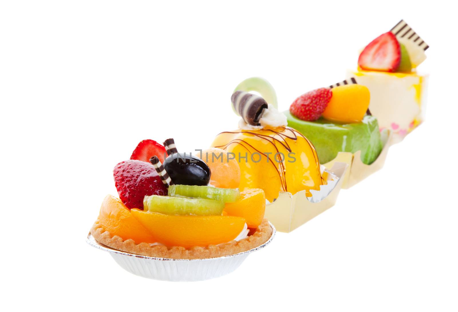 An assortment of Asian desserts, featuring (from left to right) Fruit Tart, Mango Mousse, Green Tea Cake, & Mousse Cake.  Shot on white background.