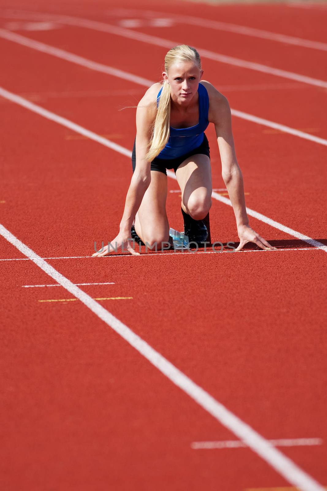 A young, track and field athlete on the starting block.