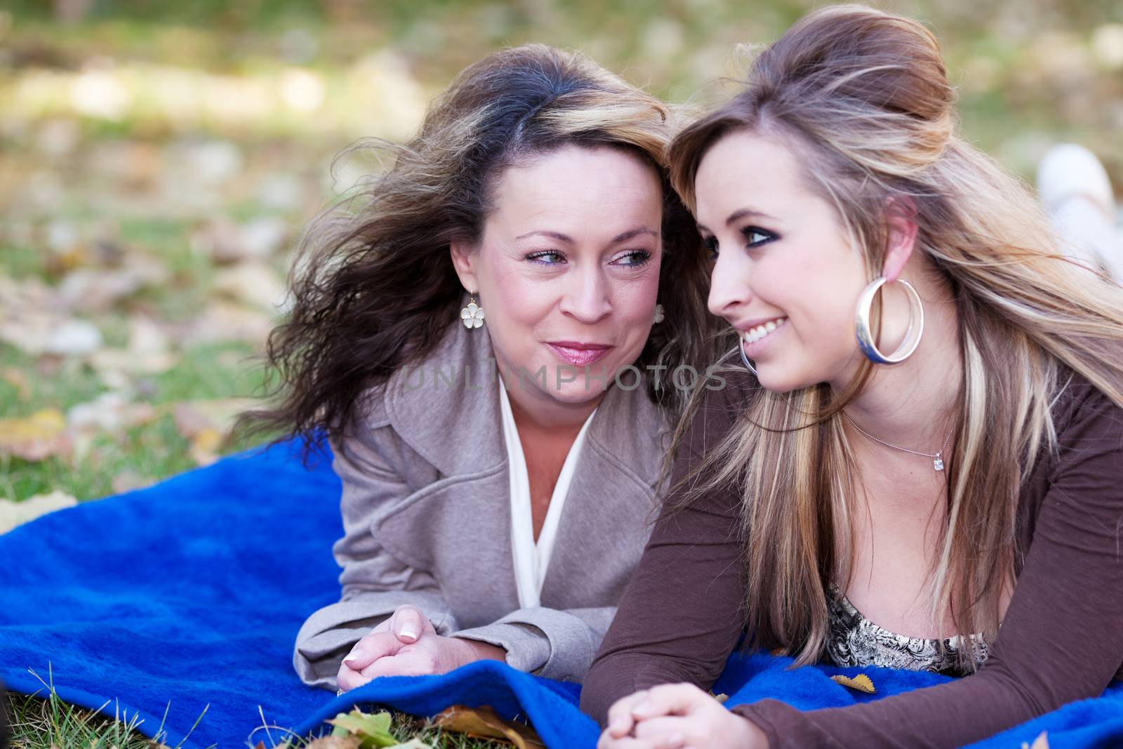 A mother looks lovingly at her daughter.  Shallow depth of field with focus on mother's expression.