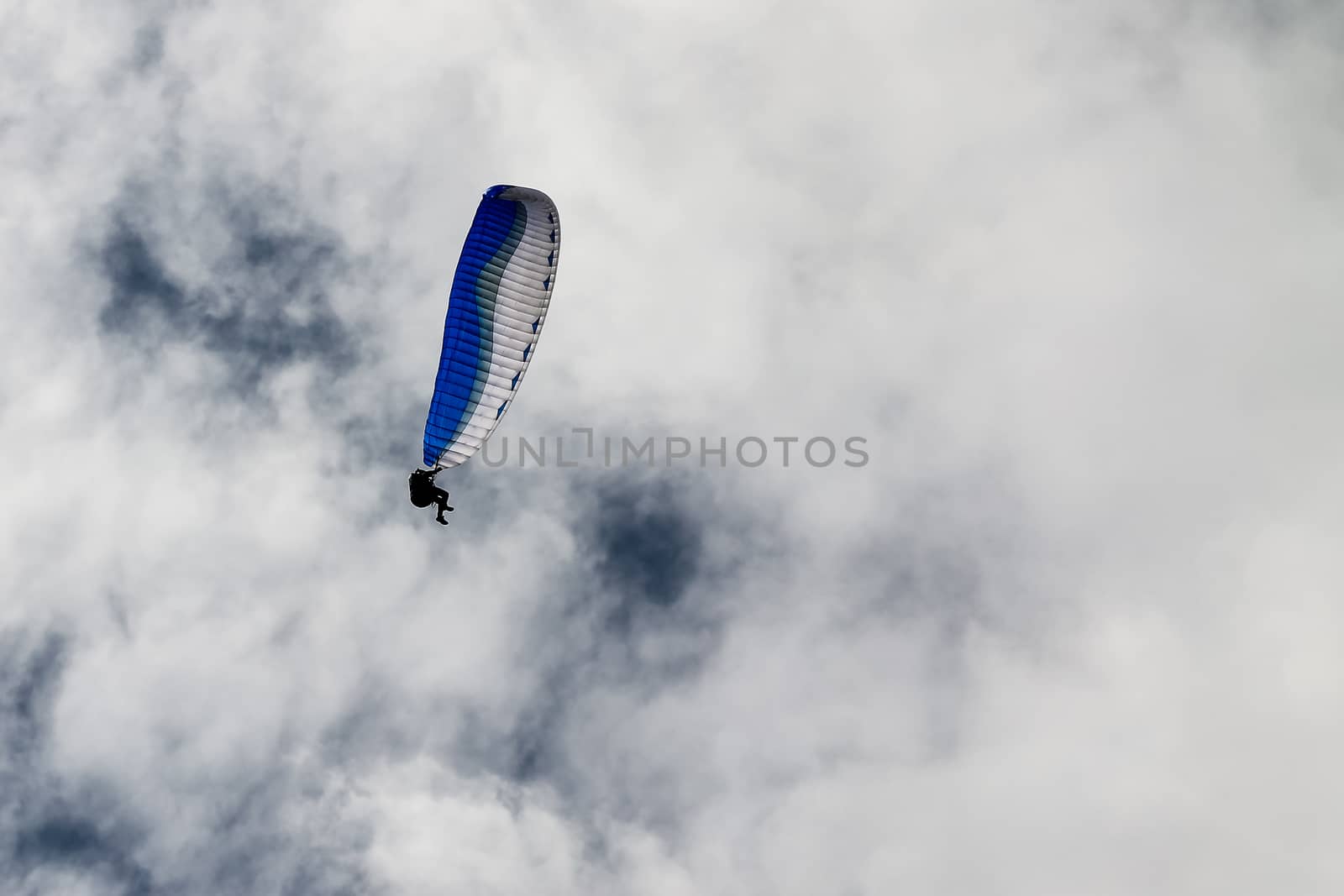 Paragliding against the white clouds