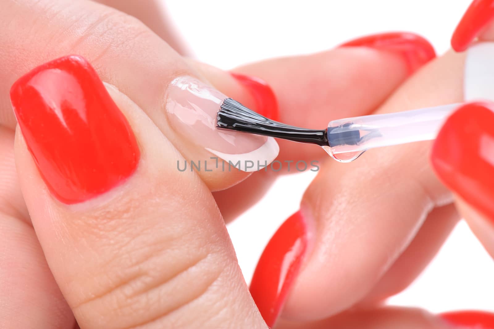 manicure applying, brushing fingernails with clear enamel