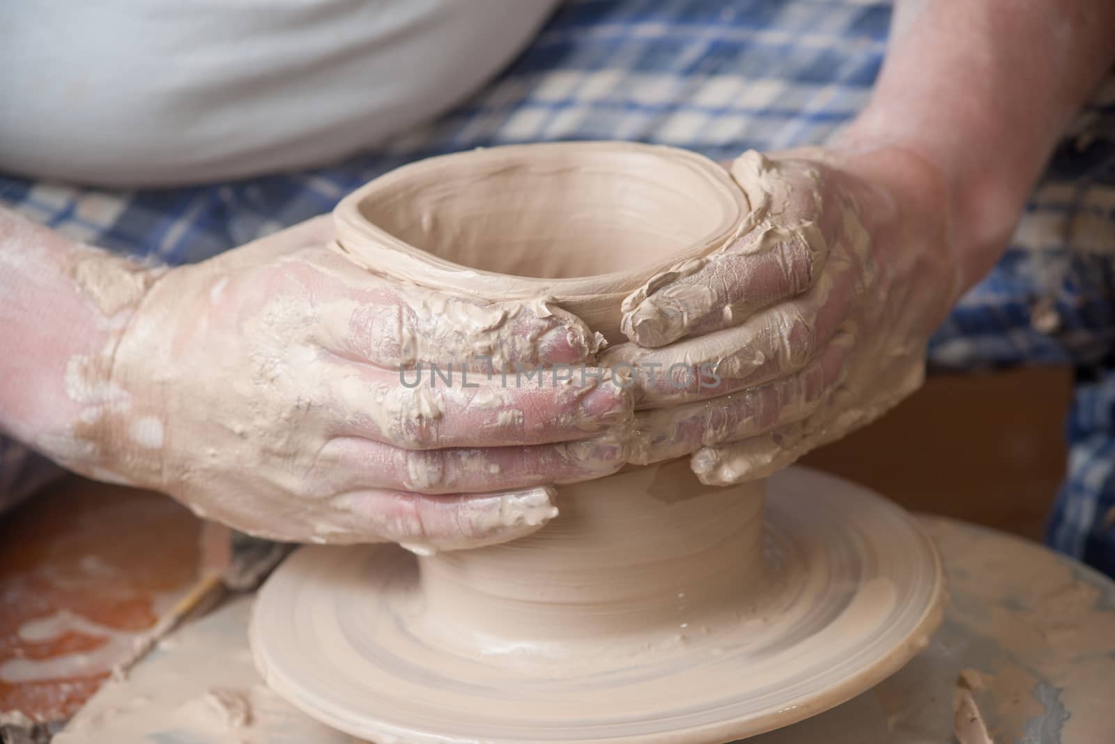 Hands of a potter, creating an earthen jar on the circle